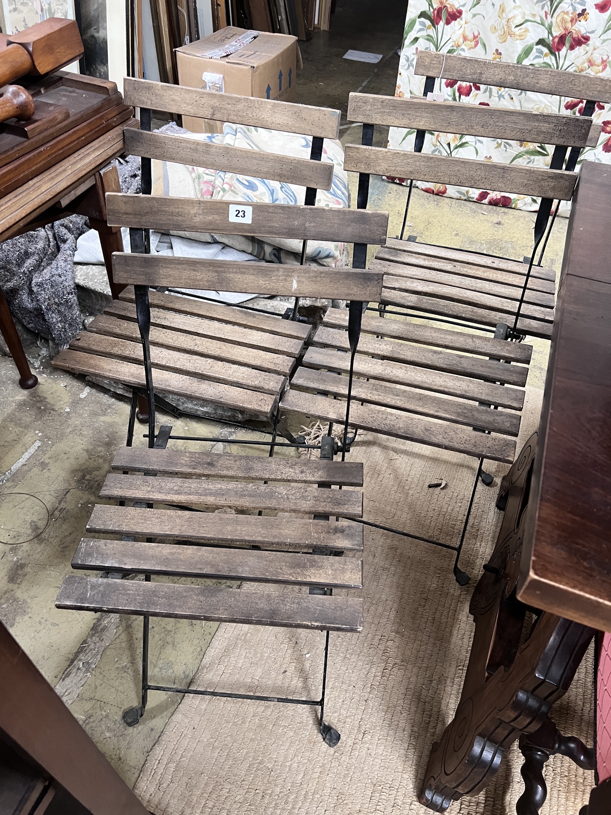 A set of four wrought iron slatted wood folding garden chairs                                                                                                                                                               