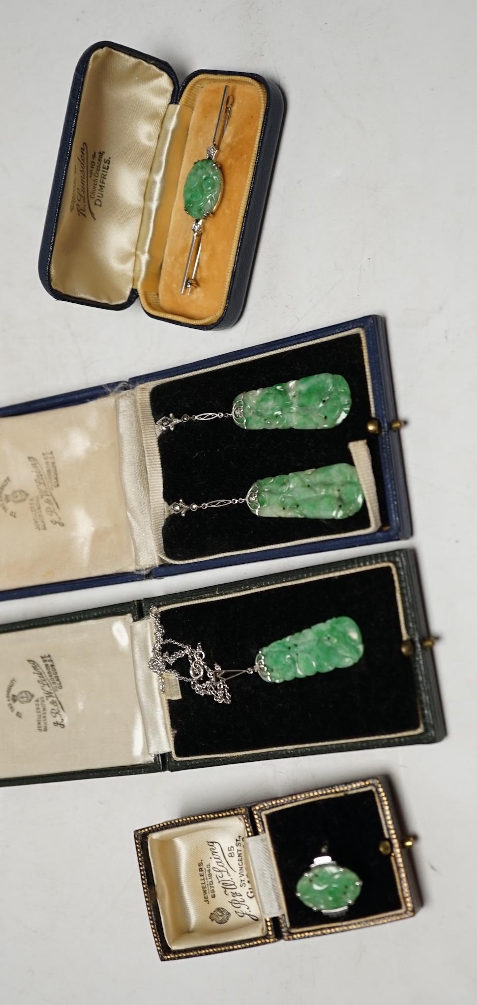 A cased 1930's white metal, single stone carved jade and two stone diamond set bar brooch, 62mm, a similar 9ct and carved jade set ring, a similar cased pair of 935 white metal, jade and marcasite set drop earrings and a