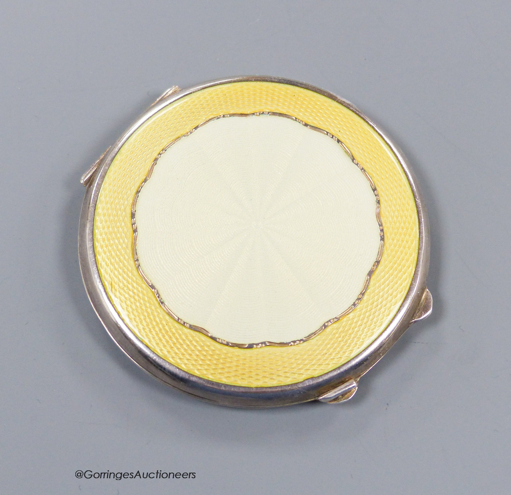 A George VI silver and yellow guilloche enamel circular compact, Birmingham, 1944, 65mm.                                                                                                                                    
