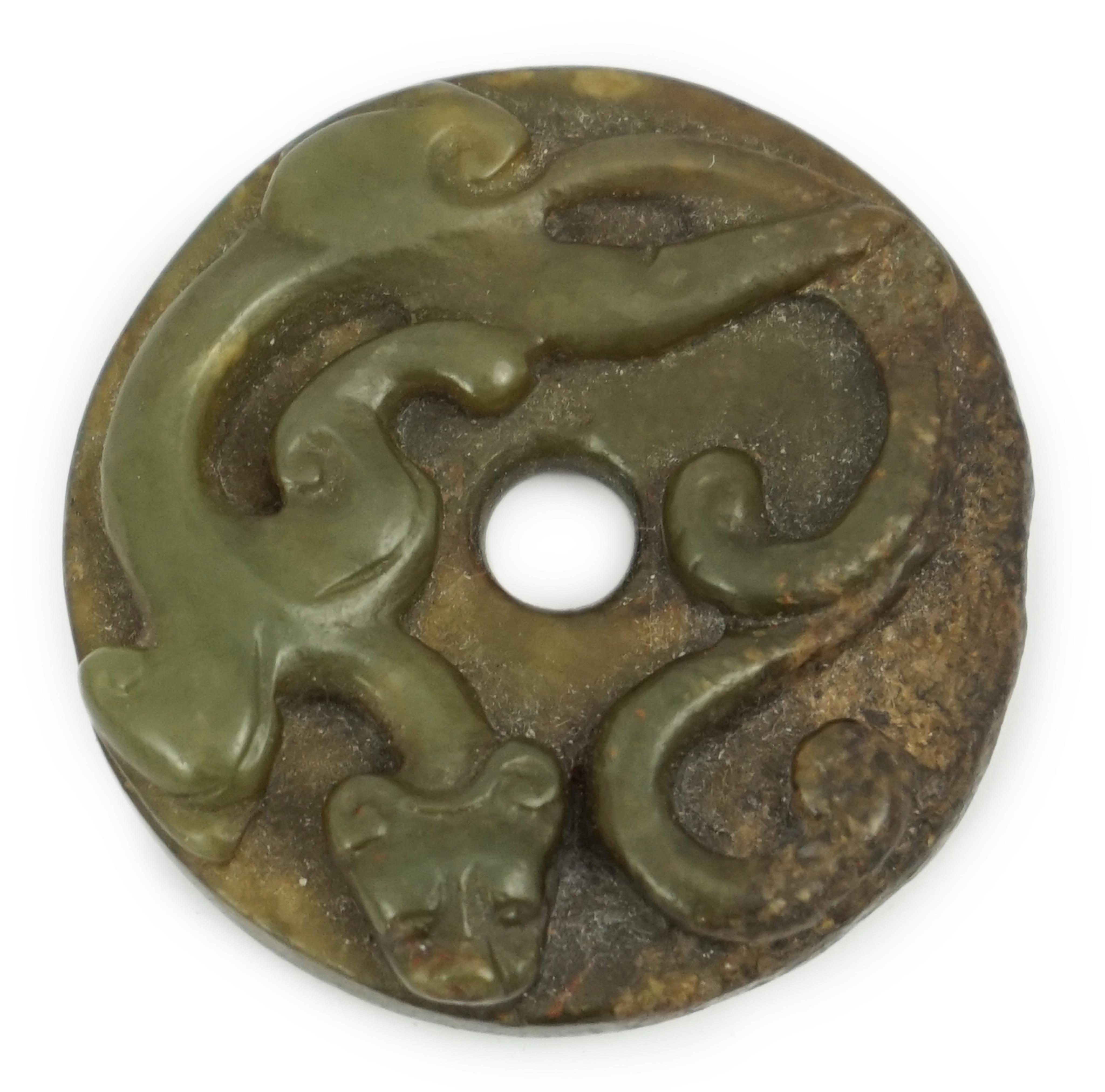 A Chinese green and brown jade bi disc, Yuan/Ming dynasty                                                                                                                                                                   