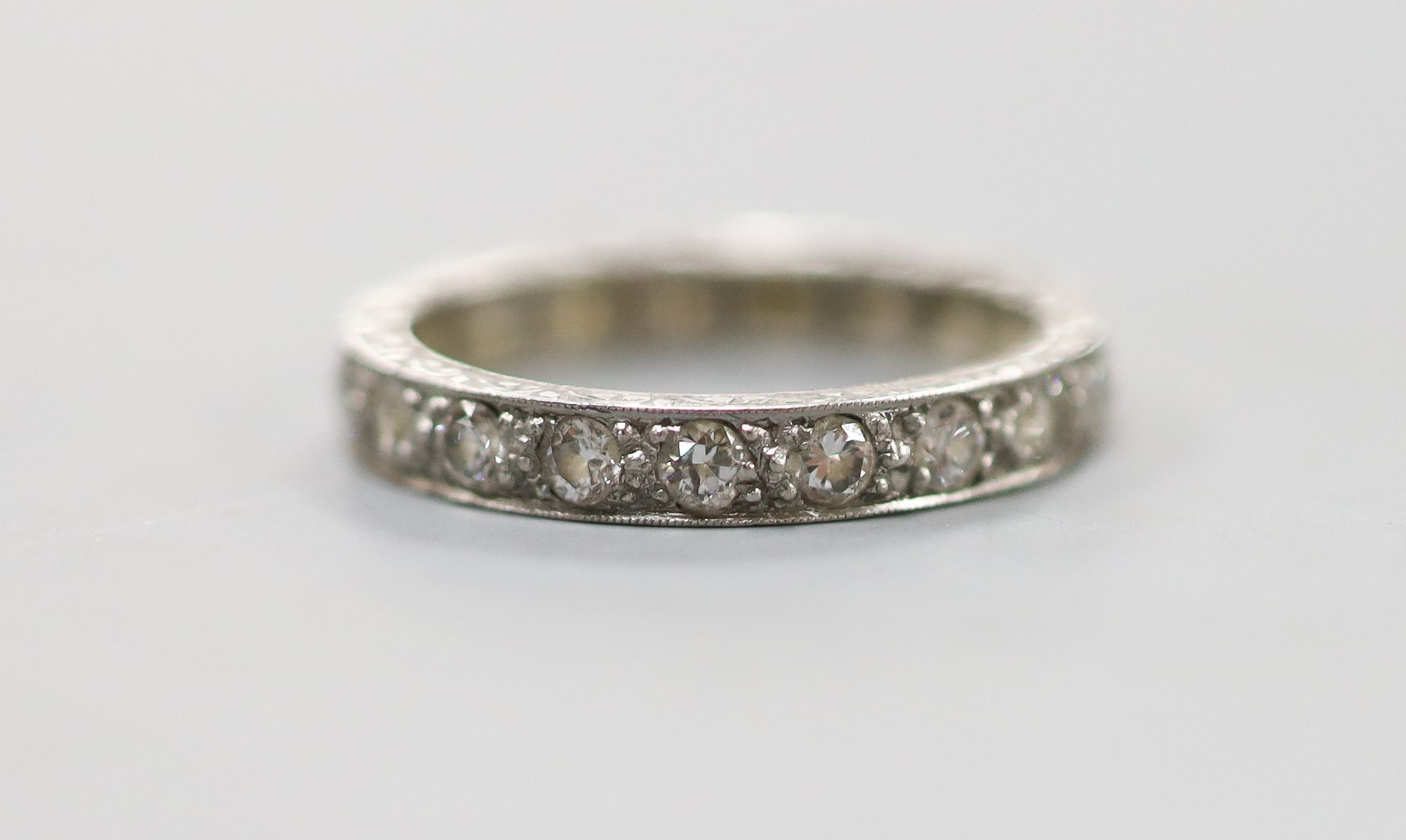 An engraved white metal and diamond set full eternity ring, size P, gross weight 4.1 grams.                                                                                                                                 