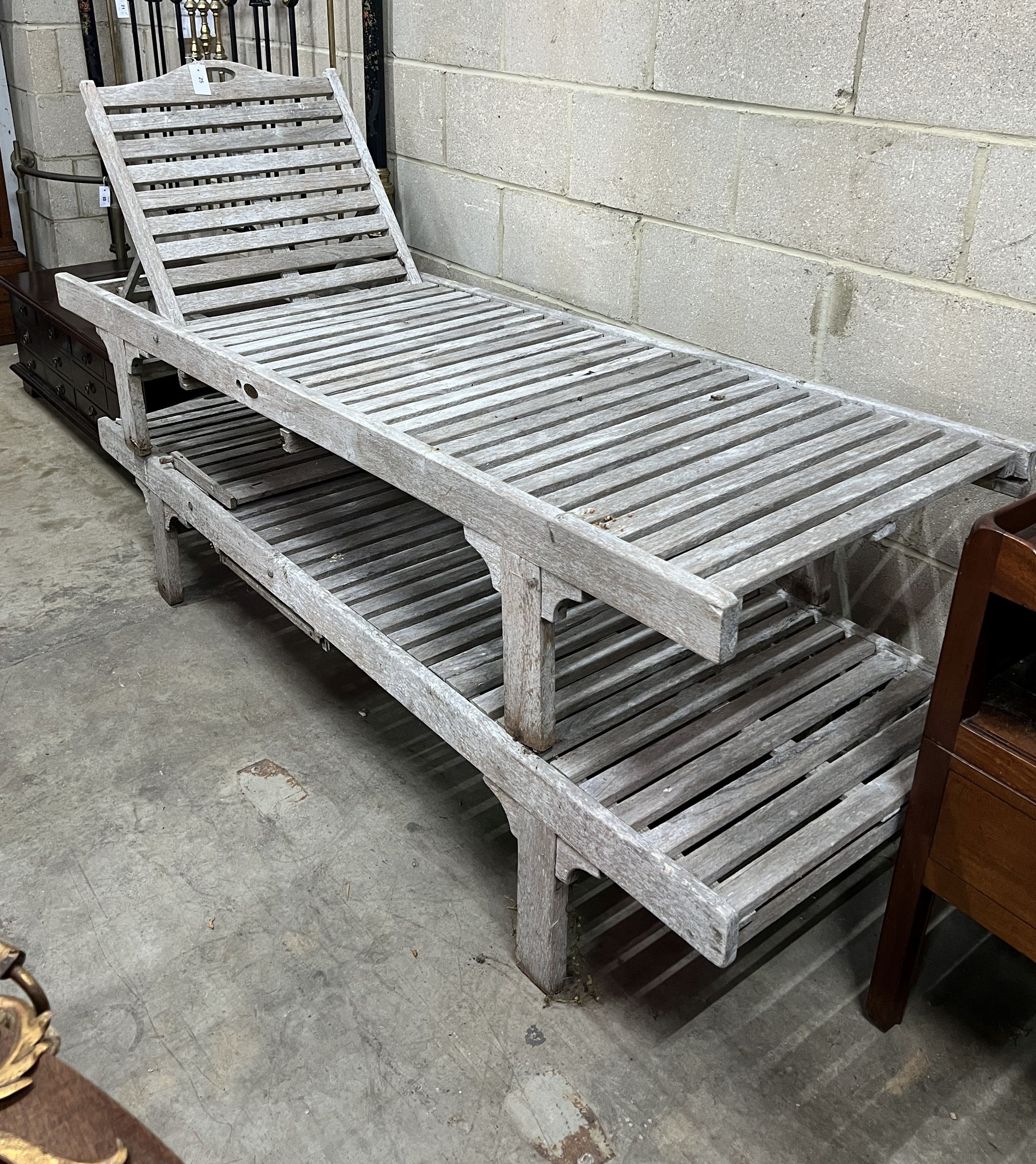 A pair of weathered teak garden loungers                                                                                                                                                                                    