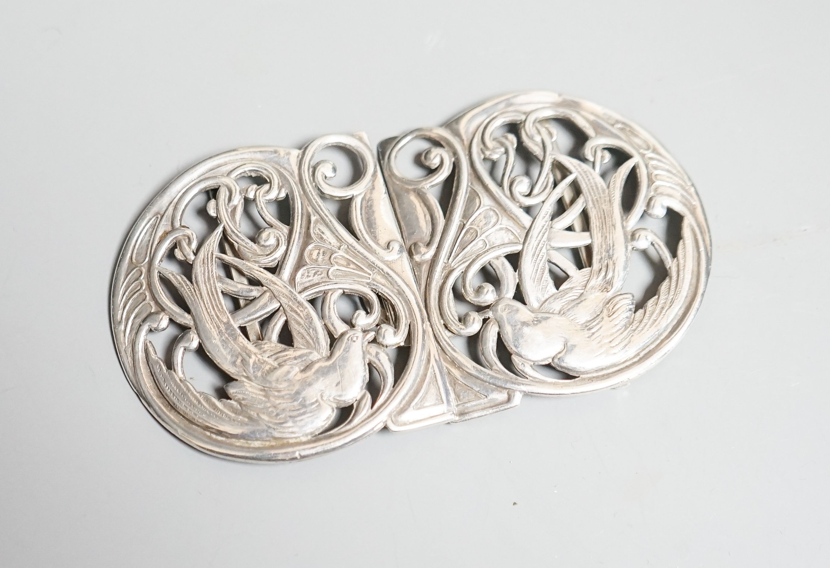 A George V Art Nouveau Liberty & Co pierced silver belt buckle, Birmingham, 1911, overall width 10.9cm.                                                                                                                     