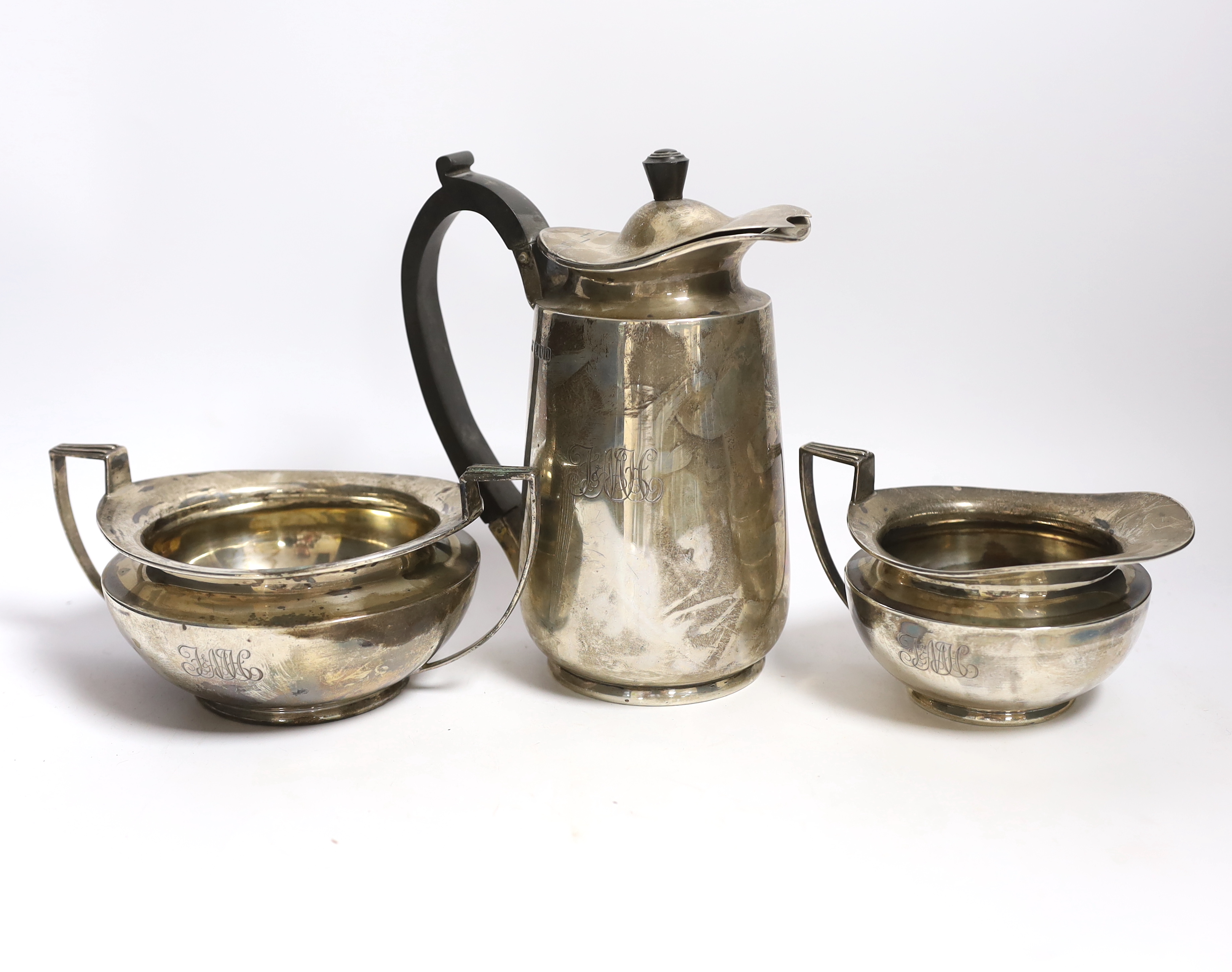 An Edwardian silver hot water pot and matching sugar bowl and cream jug, Daniel & John Welby, London, 1908/9, gross weight 45oz.                                                                                            