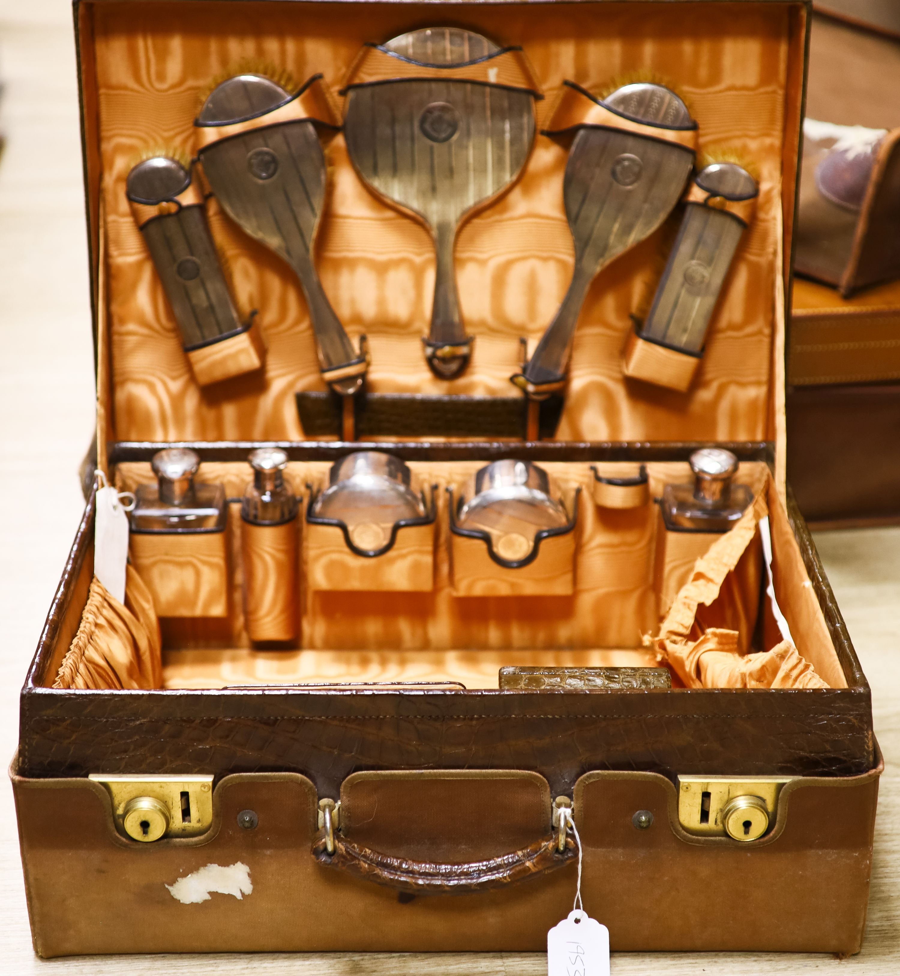 A George V crocodile skin travelling toilet case with ten engine turned silver mounted silver fittings, George Betjemann & Sons Ltd, London, 1927/8, case 50.7cm.                                                           