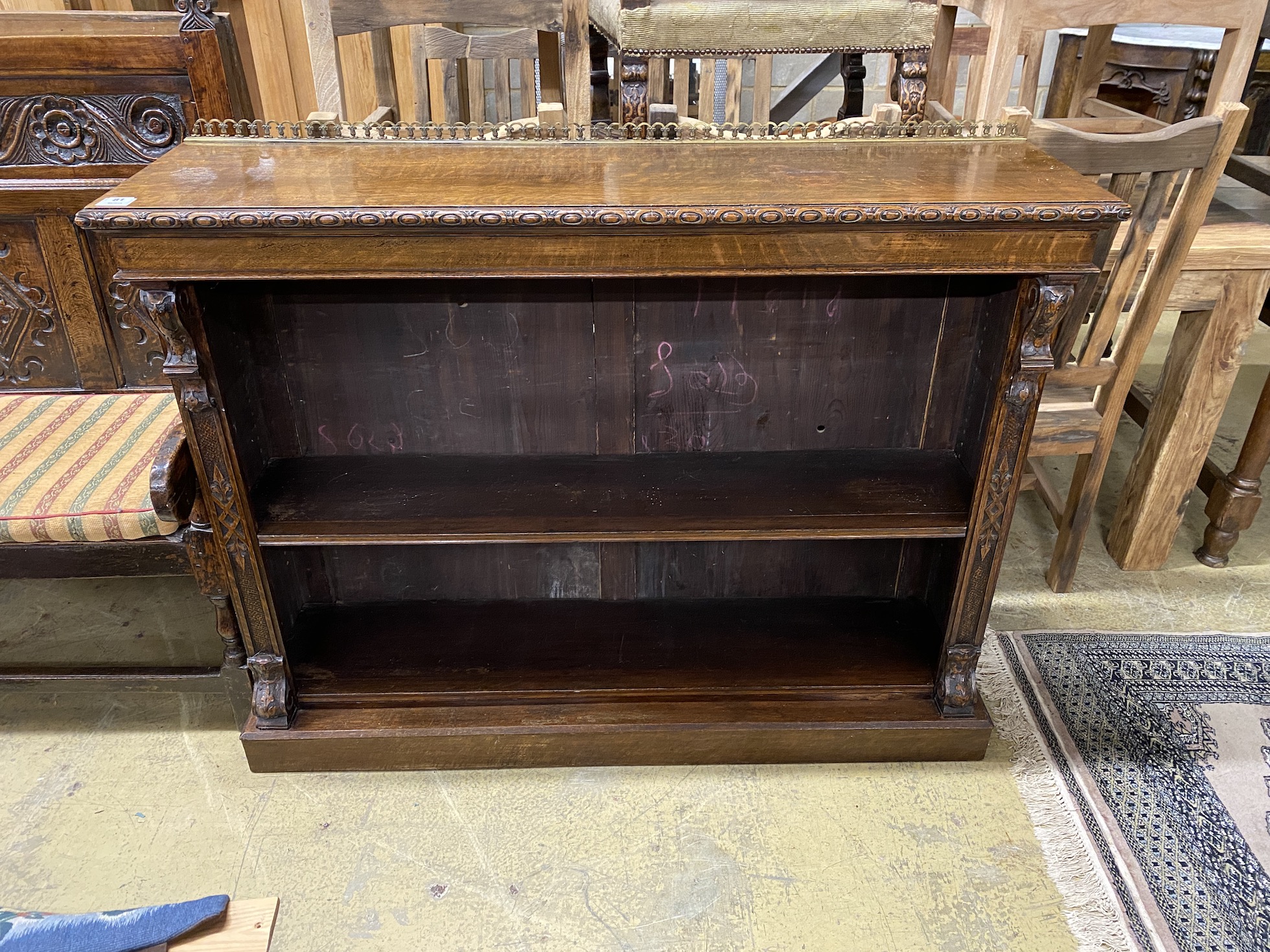 A late Victorian carved oak open bookcase, width 137cm, depth 37cm, height 108cm                                                                                                                                            