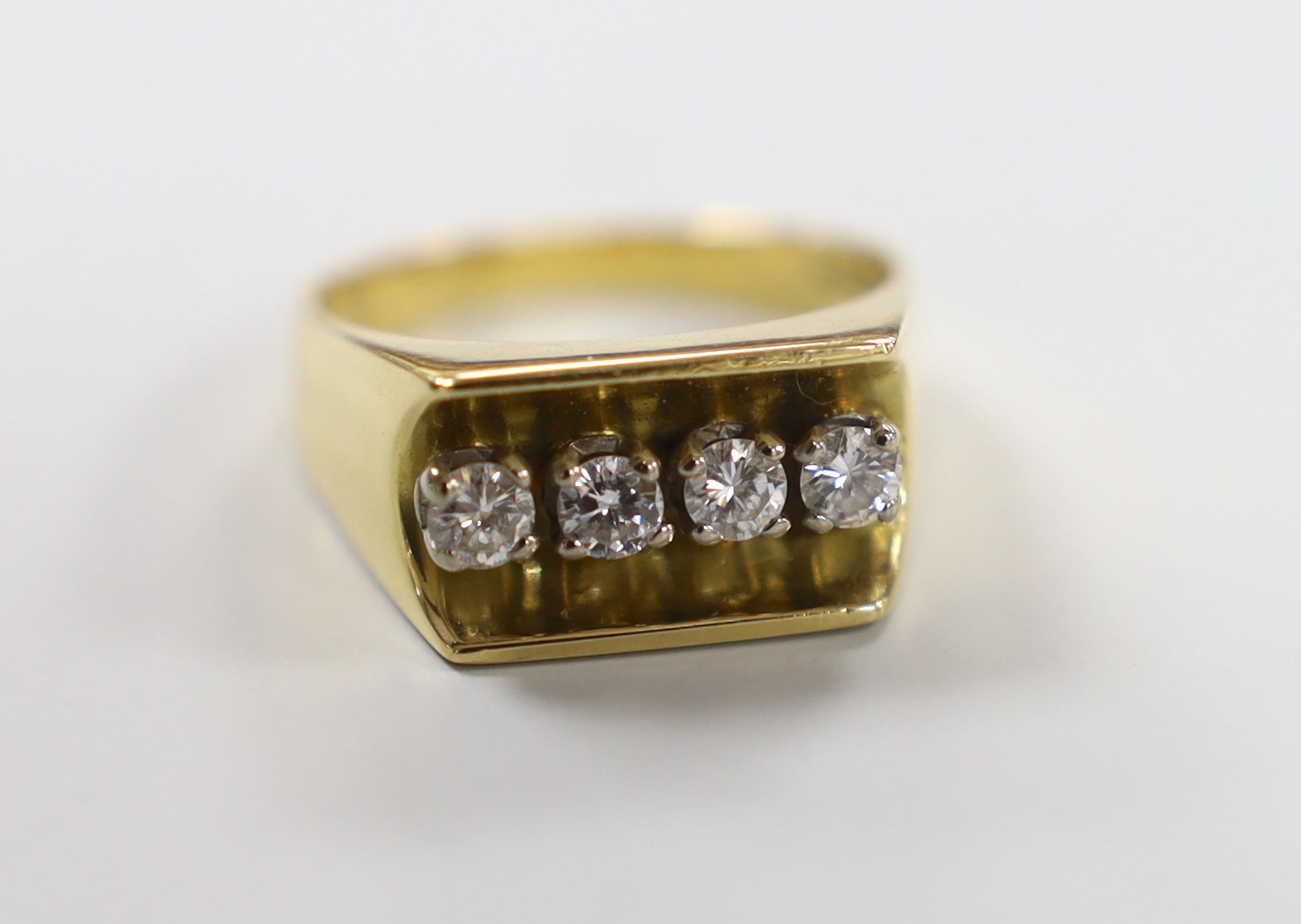 A modern 18ct gold and four stone diamond set dress ring, size Q/R, gross weight 10.6 grams.                                                                                                                                