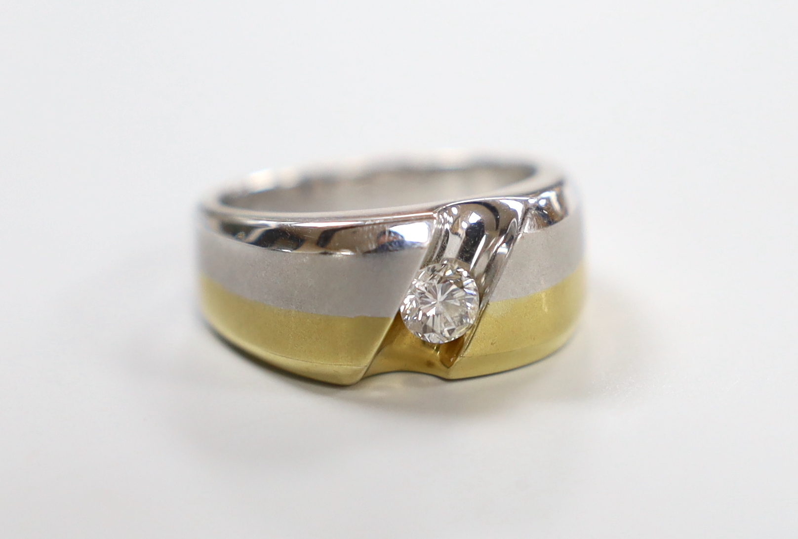 A modern two tone yellow and white metal solitaire diamond set ring, size S, gross weight 12.5 grams.                                                                                                                       