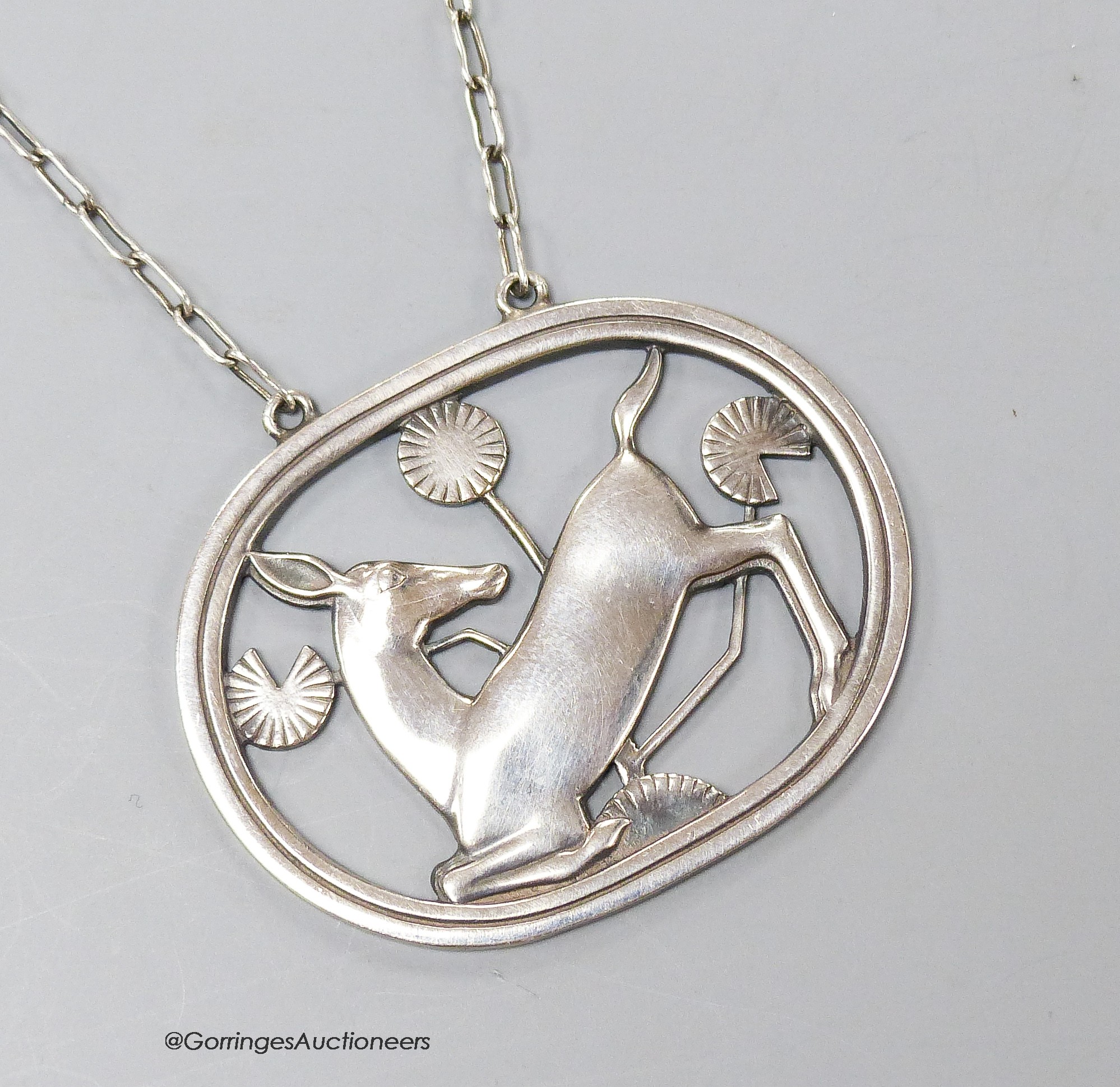 A George Jensen sterling 'kneeling deer' pendant necklace, design no. 95, 43mm, chain 58cm.                                                                                                                                 