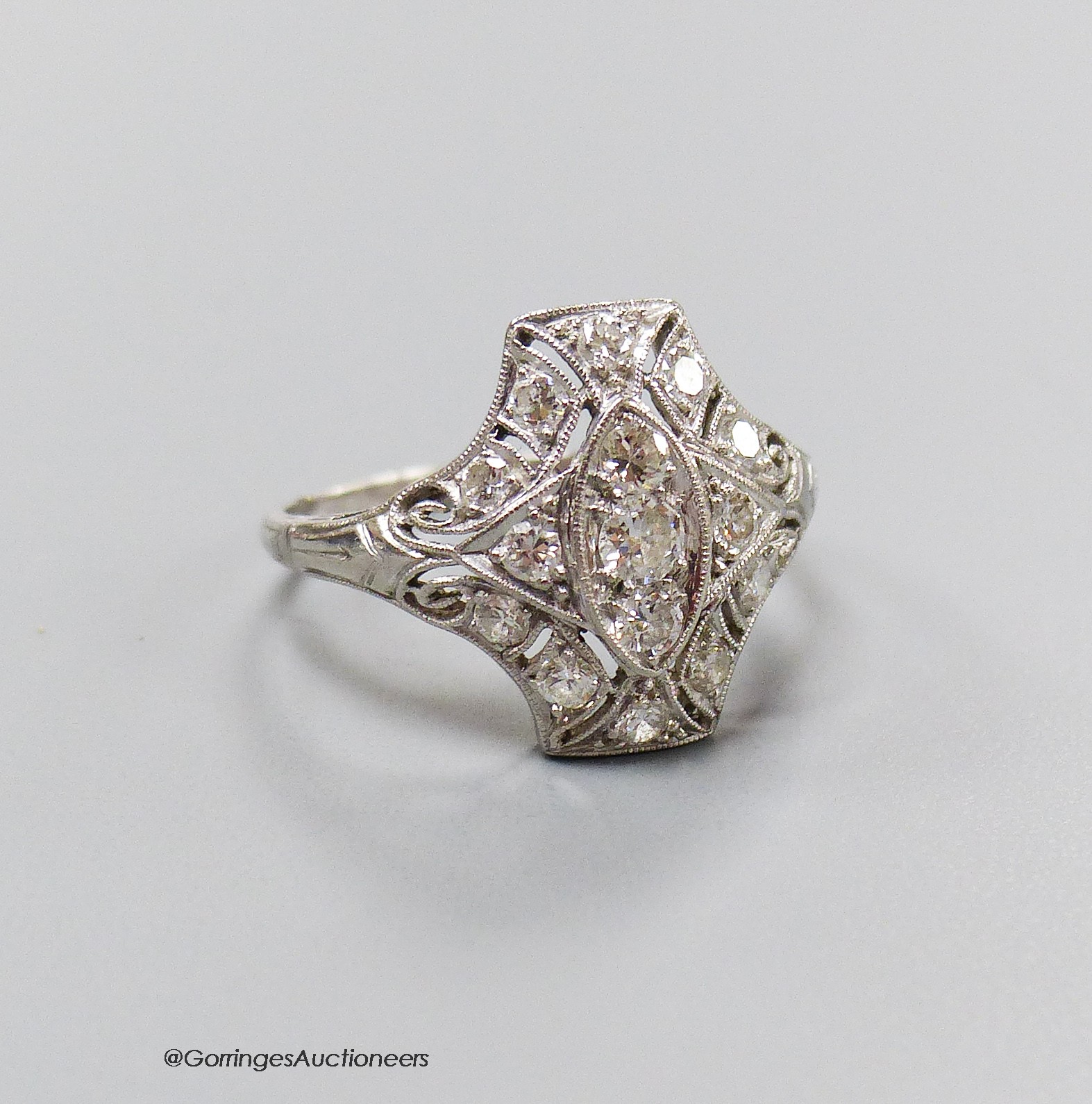 A 1920's pierced white metal and diamond cluster dress ring, size M, gross 3.5 grams.                                                                                                                                       