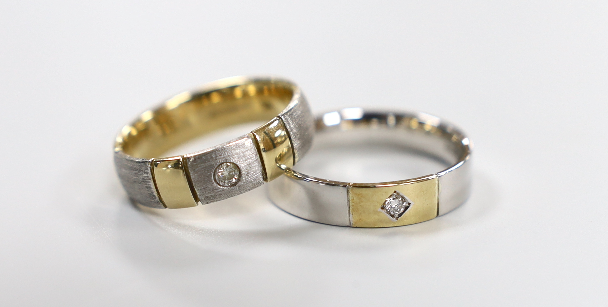 Two modern two colour 9ct gold and diamond set bands, sizes T & W, gross weight 12.6 grams.                                                                                                                                 