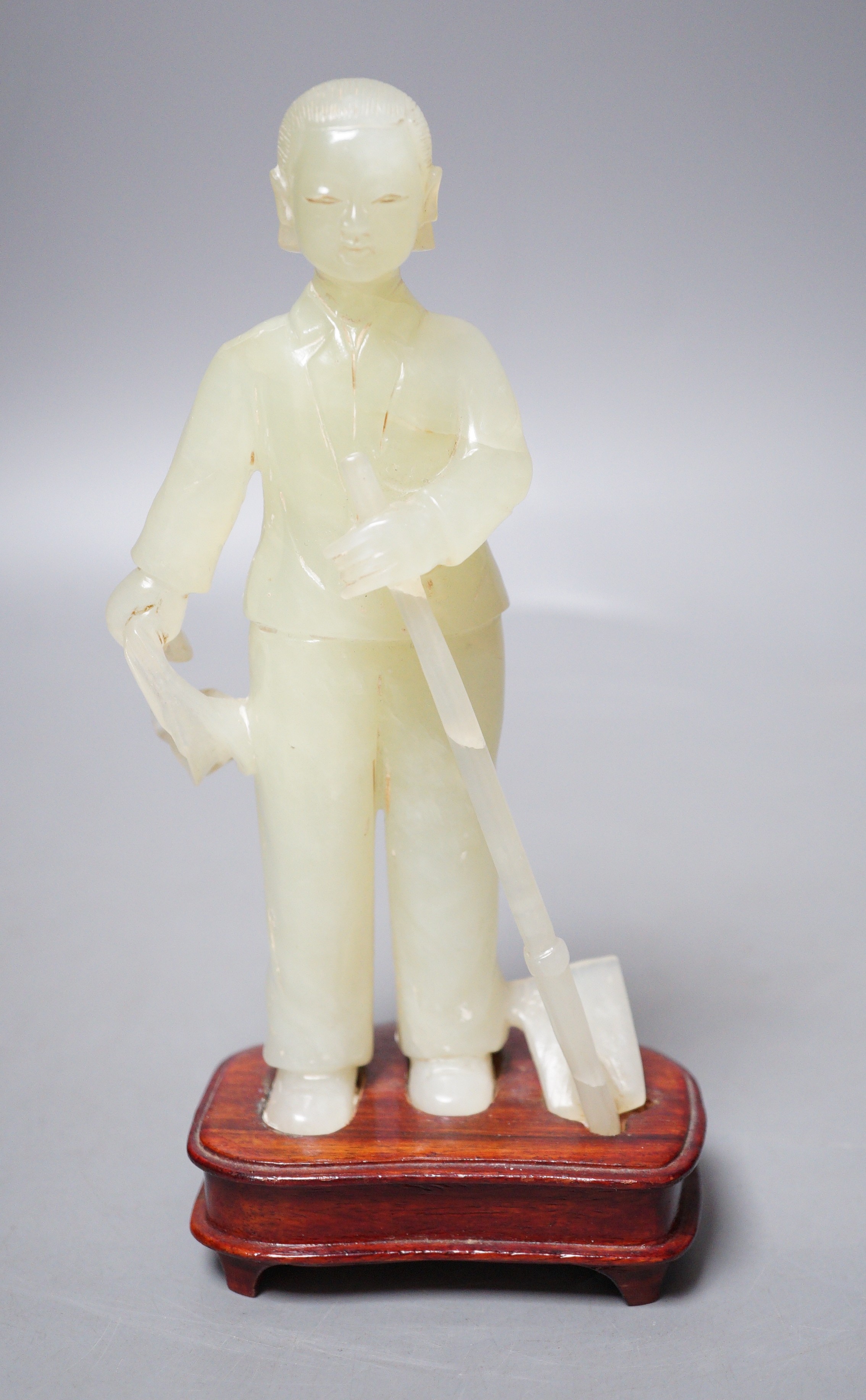 A Chinese carved bowenite jade figure of a worker on hardwood stand, 19cm                                                                                                                                                   