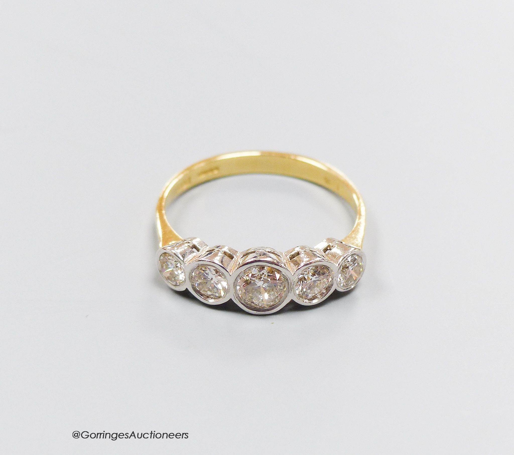 An 18ct gold five stone diamond ring, size T, gross 4.3g.                                                                                                                                                                   