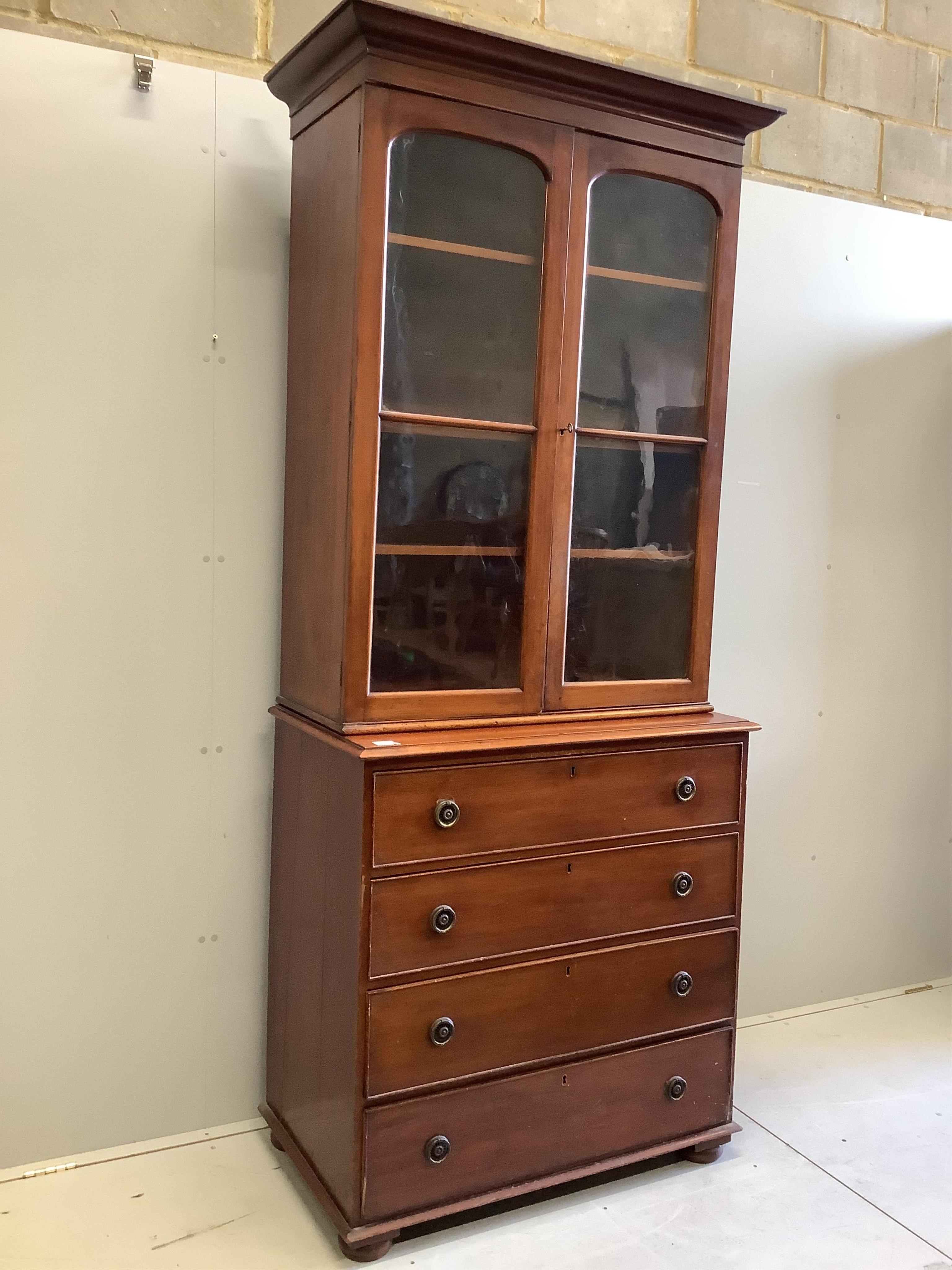 An Edwardian mahogany chest, fitted over with a two door glazed bookcase, width 96cm, depth 55cm, height 233cm. Condition - fair                                                                                            