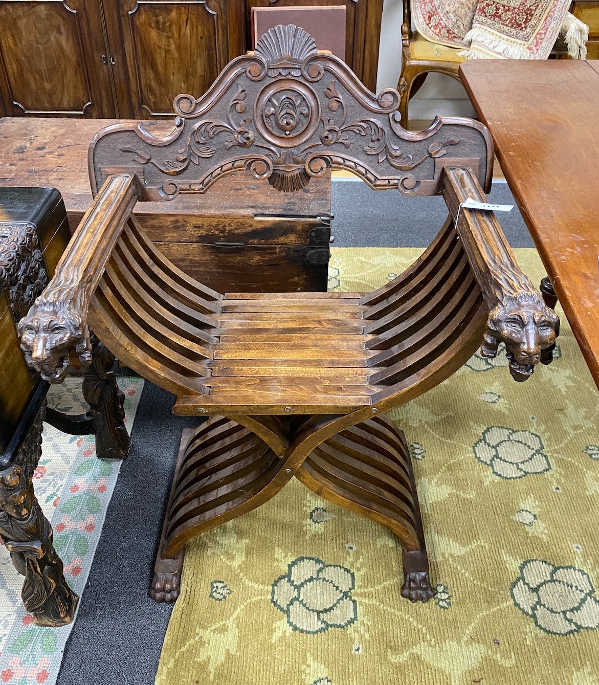 An Italian carved walnut folding Savaranola type elbow chair, width 66cm, depth 51cm, height 92cm                                                                                                                           