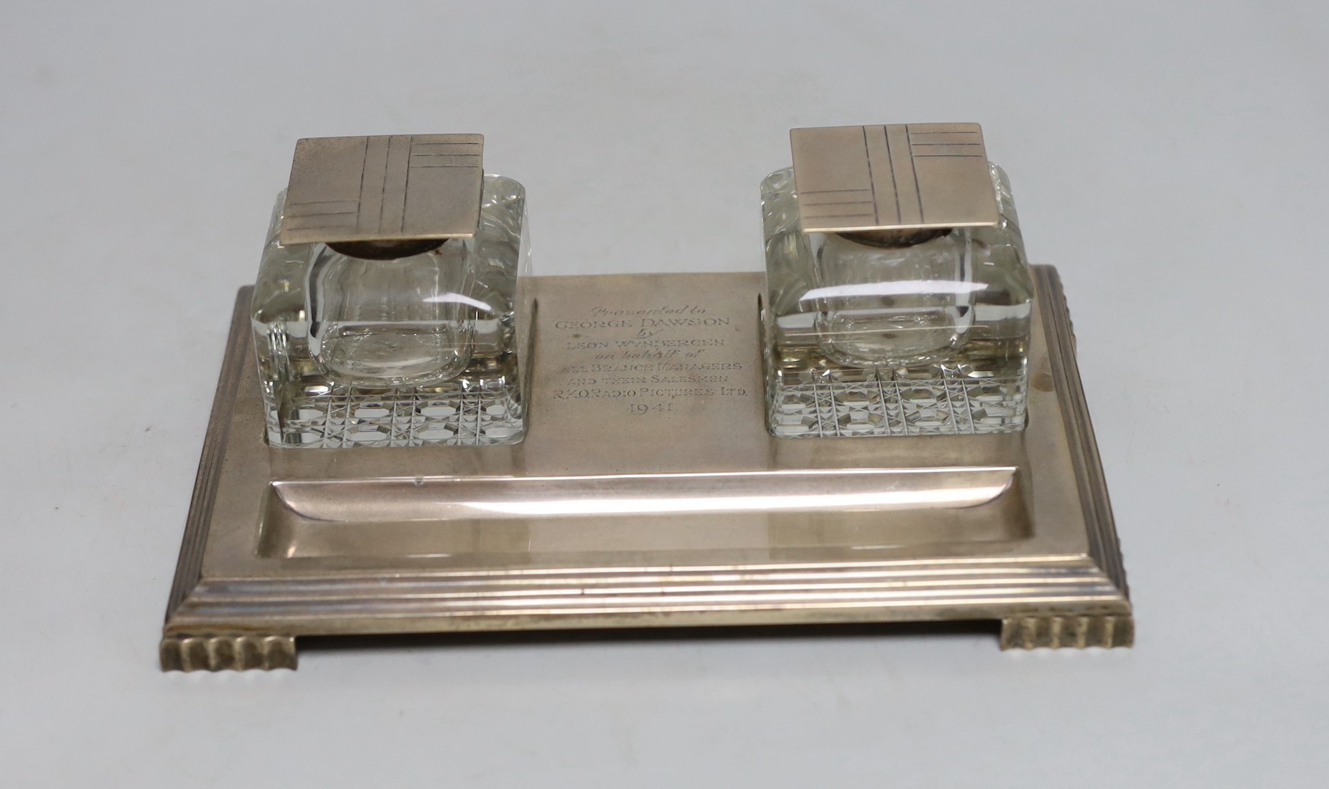 A George VI Art Deco silver presentation rectangular inkstand, with two mounted glass wells, with engraved inscription, Mappin & Webb, Sheffield, 1939, 22.2cm, base 14.8oz.                                                
