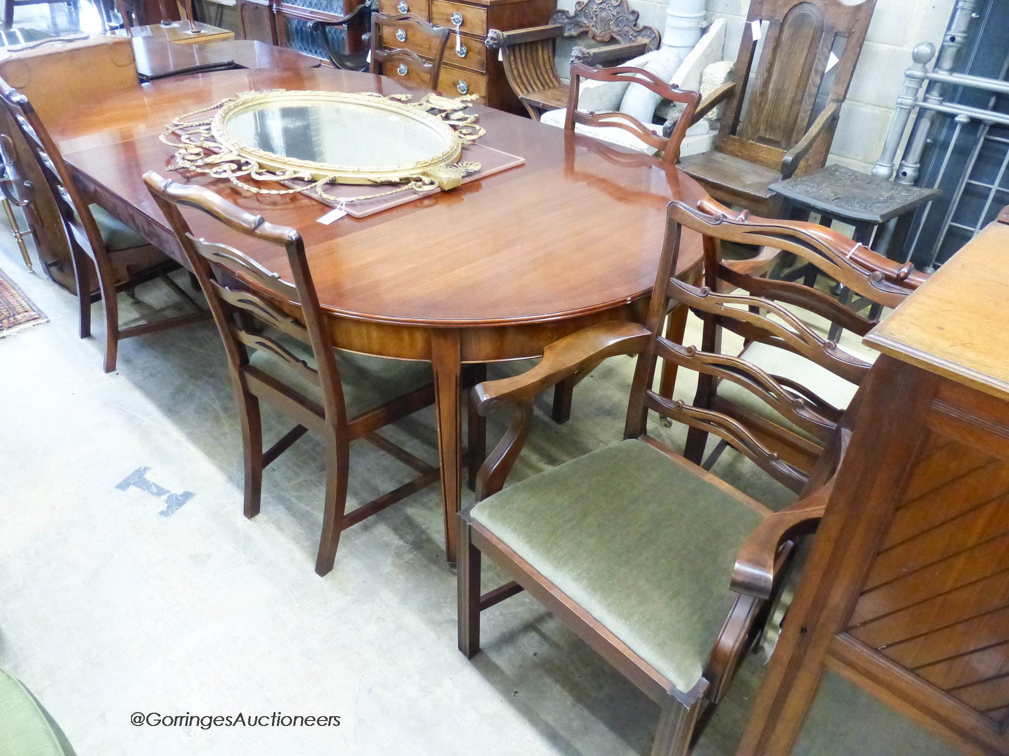 A reproduction George III Style mahogany D-end extending dining table, 236cm extended, 2 spare leaves. W-130, H-74cm. Together with six ladder back dining chairs, two with arms.                                           