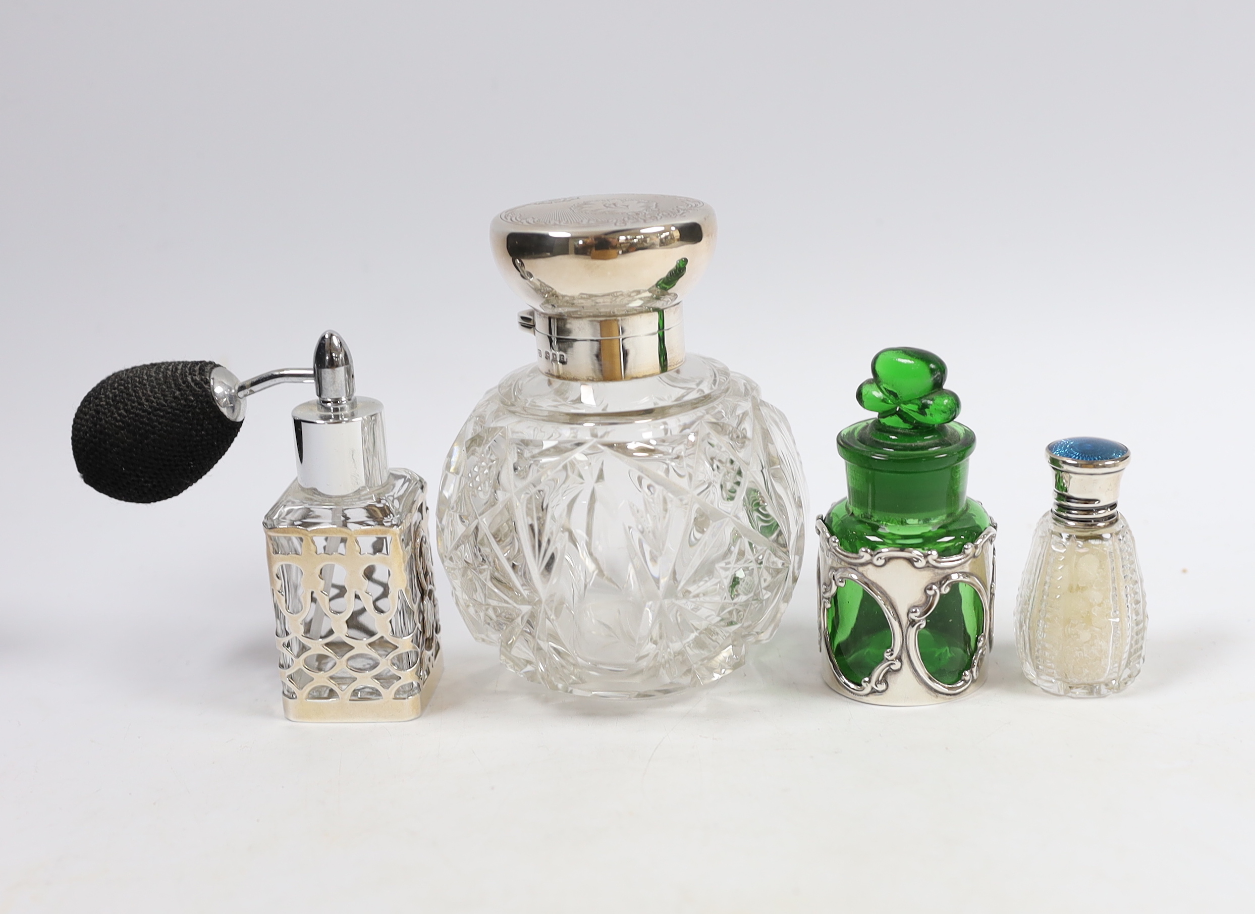 A George V silver mounted cut glass globular scent bottle, London, 1918, lacking stopper?, 11.2cm and three other silver mounted toilet jars.                                                                               