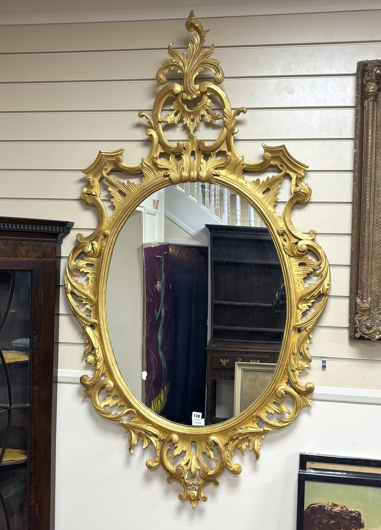 A George III style carved giltwood oval wall mirror, width 89cm, height 160cm                                                                                                                                               