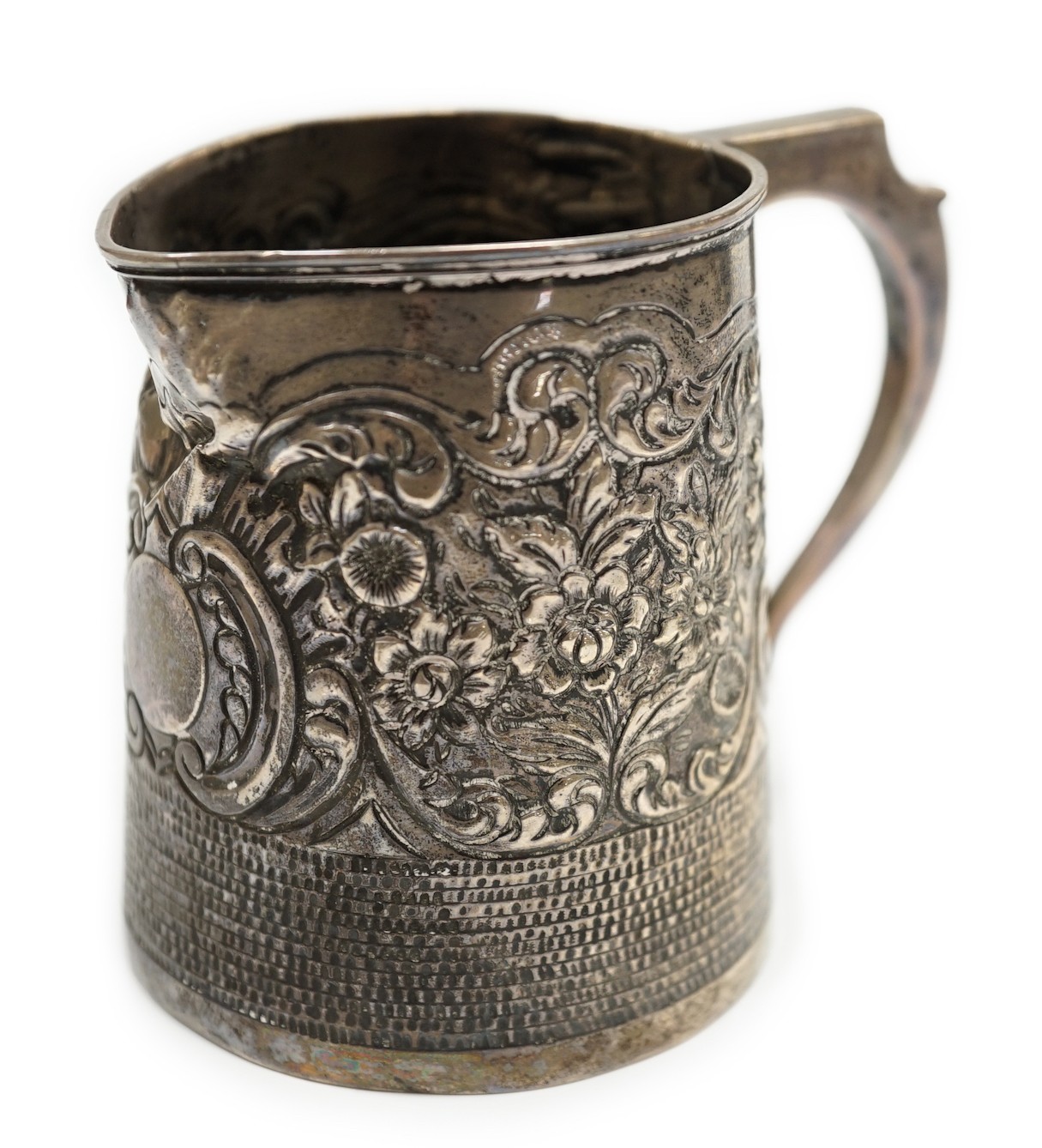 A George III silver mug, with later embossed decoration (af.), Charles Hougham?, London, 1812, height 81mm.                                                                                                                 