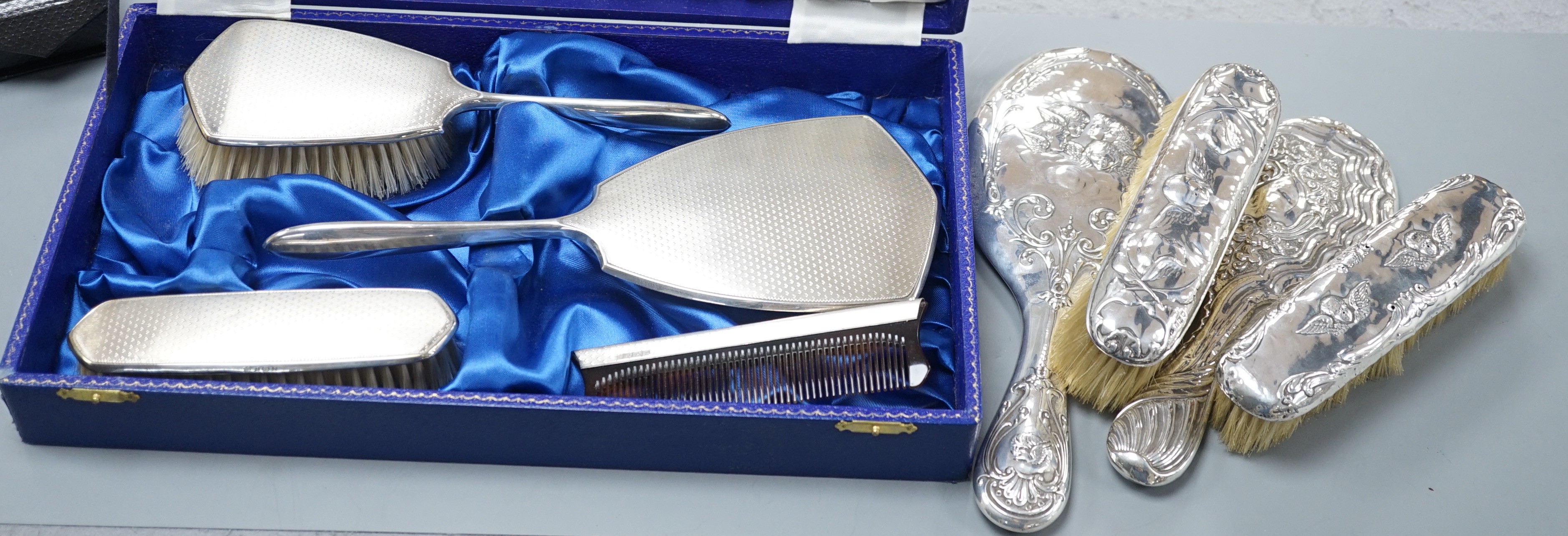 A cae 1970's engine turned silver mounted four piece mirror and brush set, two silver mounted hand mirrors and two silver mounted brushes.                                                                                  