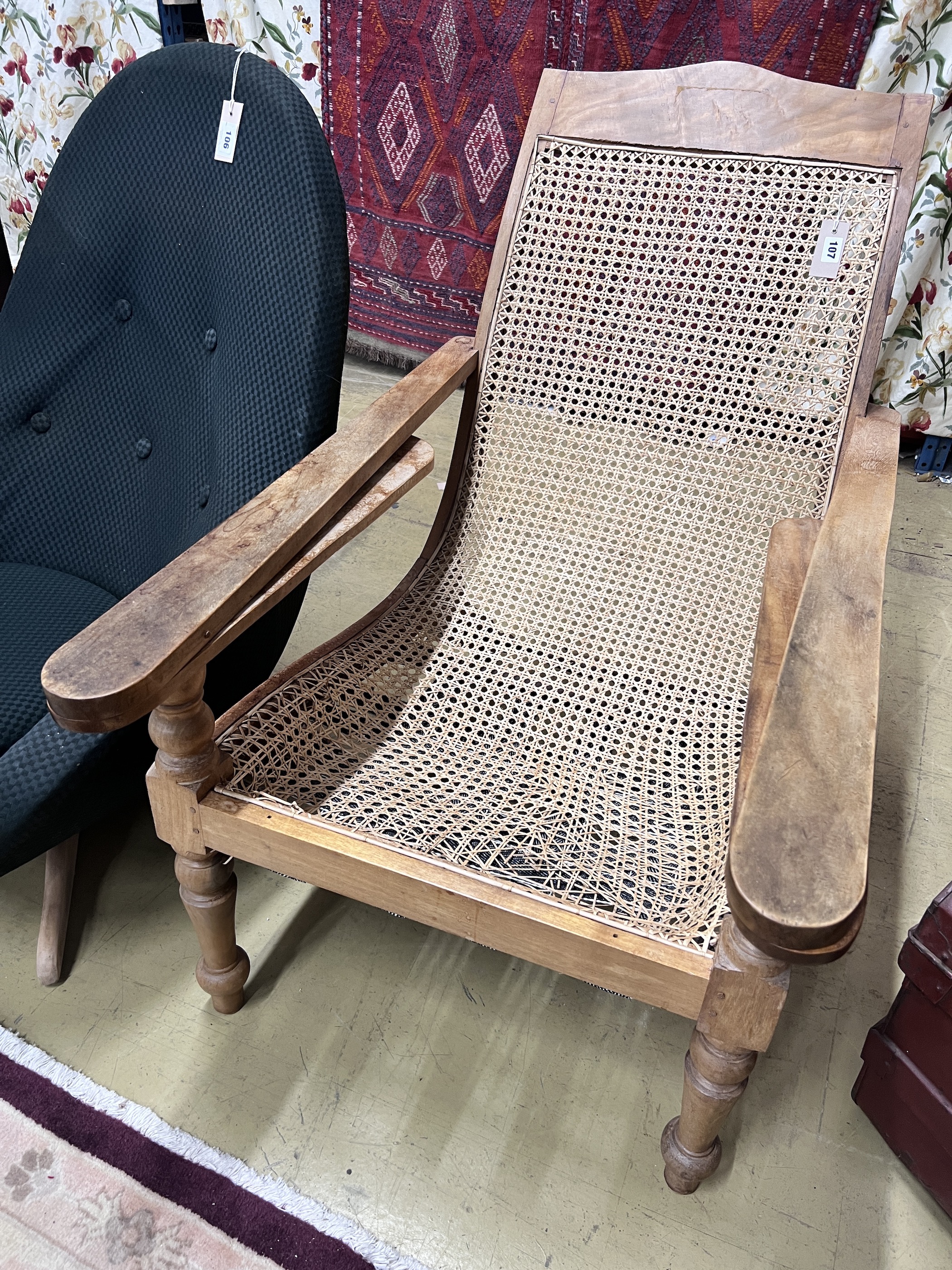 A caned hardwood plantation chair, cane seat damaged, width 66cm, depth 92cm, height 94cm                                                                                                                                   