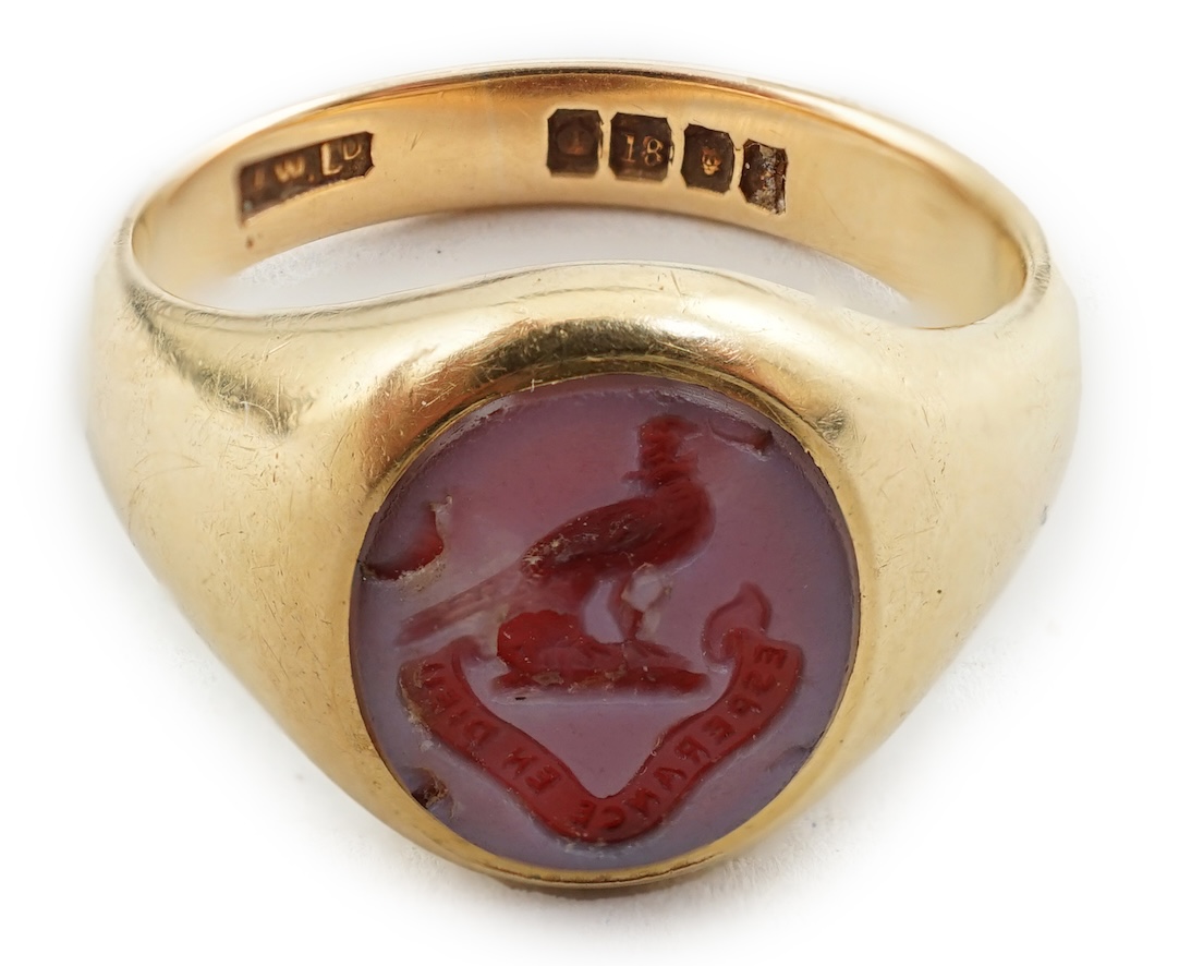 A George V 18ct gold and sardonyx set signet ring, the oval stone carved with family crest                                                                                                                                  