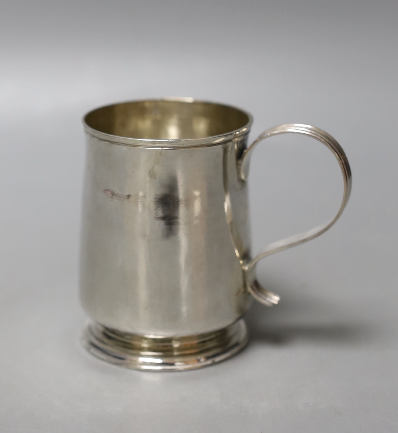 A small late George I silver mug, with reeded handle, by George Greenhill Jones, London, 1725, 77mm, 112 grams, (a.f.).                                                                                                     