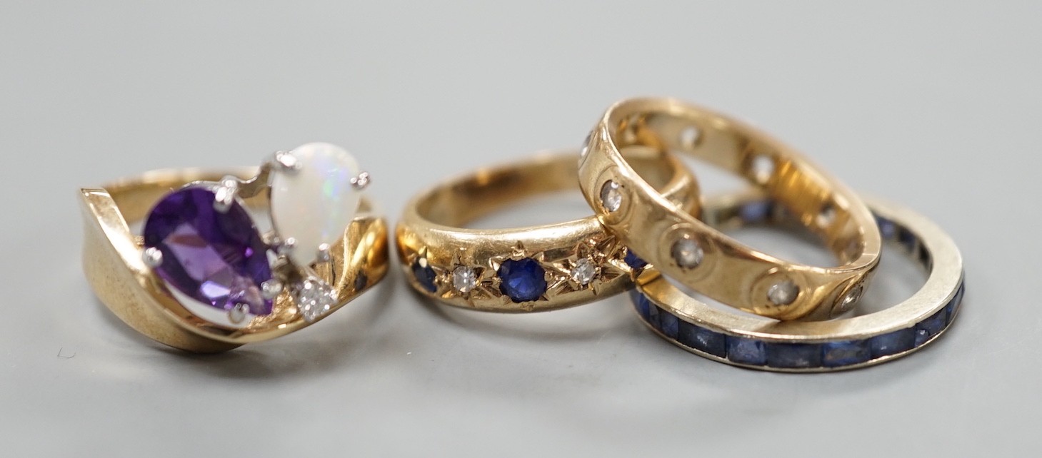 A 10k yellow metal, amethyst, white opal and diamond set dress ring, size N, gross weight 4.6 grams, two 9ct and gem set rings and a white metal and sapphire? set full eternity ring, gross weight 8.2 grams.              