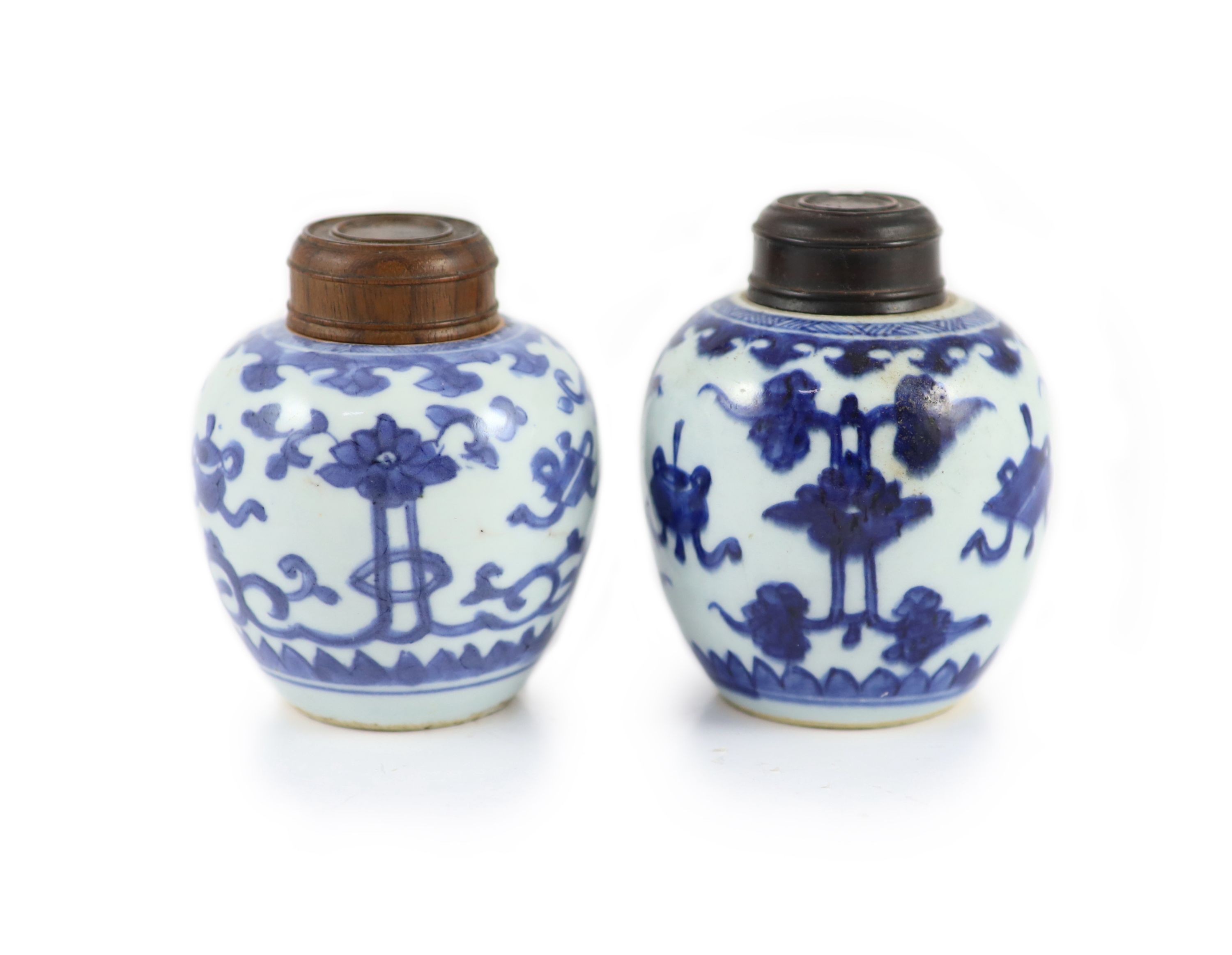 A near pair of Chinese blue and white ovoid jars, Kangxi period, 10 cm high, wood covers                                                                                                                                    