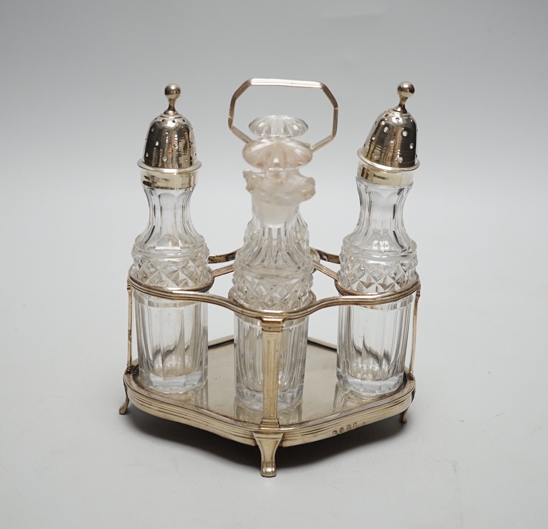 A George III small silver cruet stand, by Robert & David Hennell, London, 1799, of quatrefoil shape, with four associated glass bottles, two with silver mounts, height 17cm.                                               
