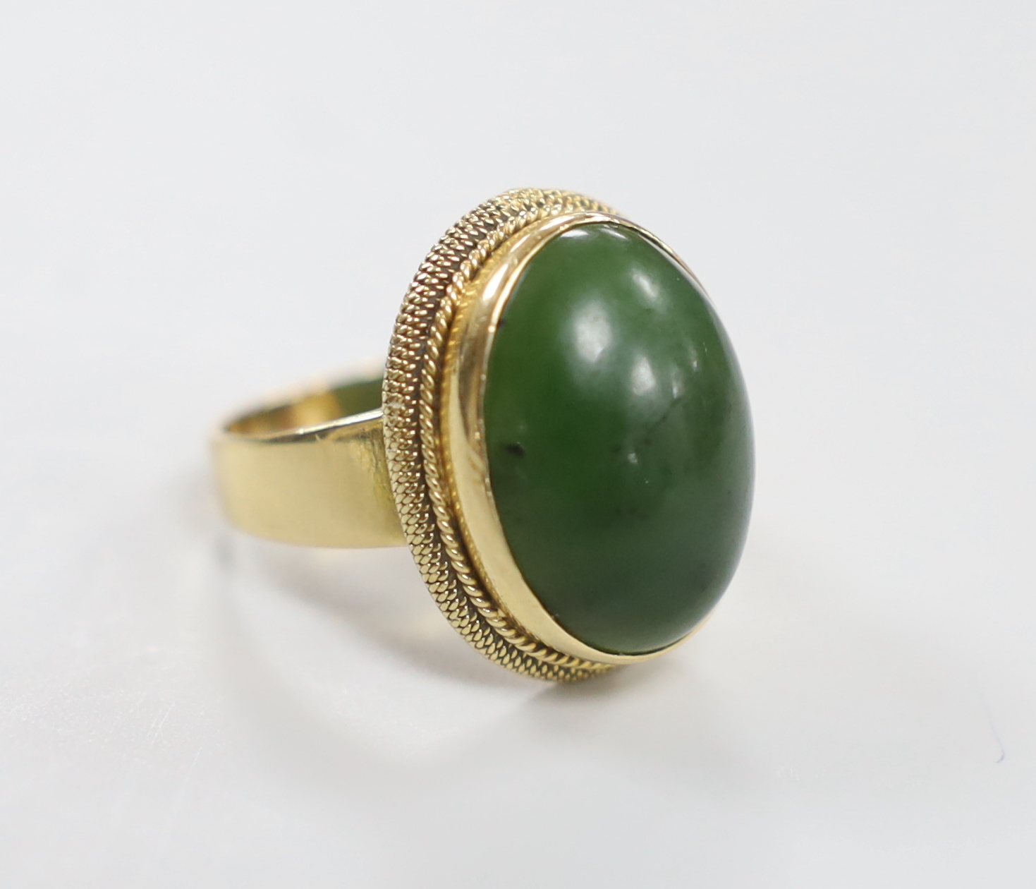 An 18k and cabochon spinach green nephrite green set dress ring. size Q/R                                                                                                                                                   