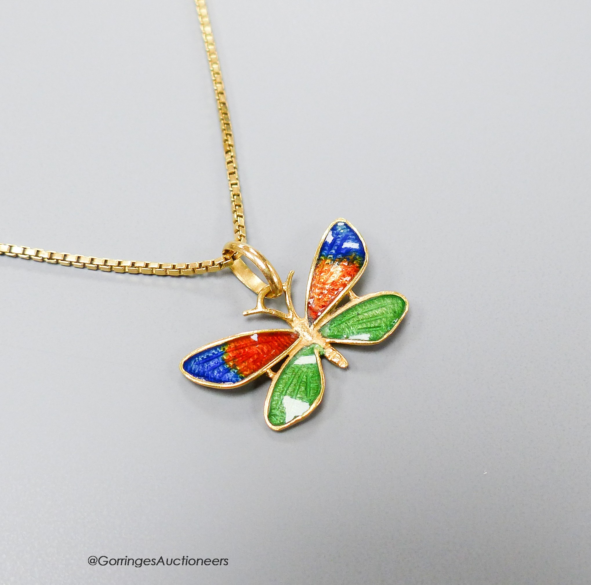 A three colour enamelled butterfly pendant, 23mm (enamel a.f.), on an Italian 750 yellow metal chain, 49cm, 5.2 grams.                                                                                                      