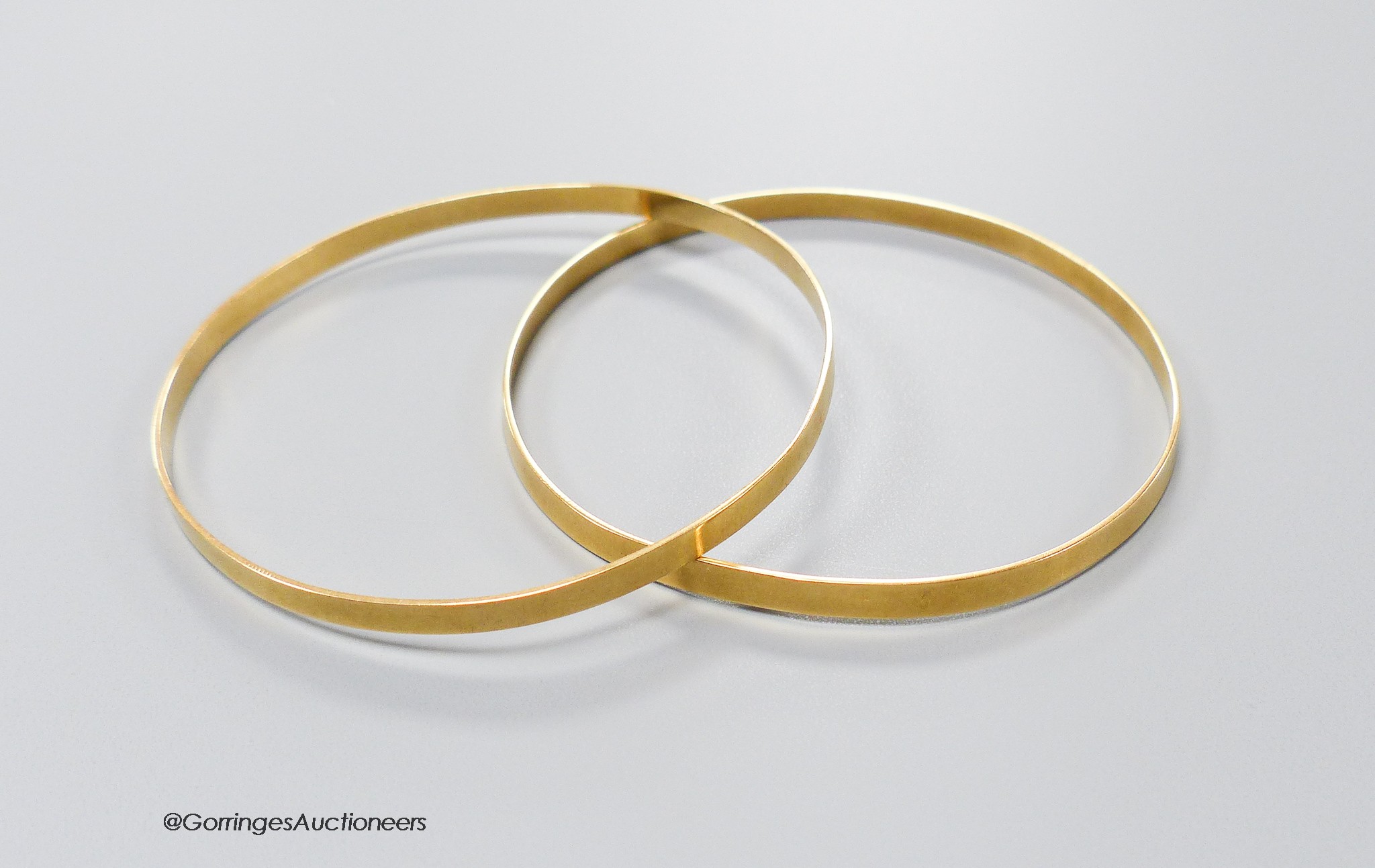 A pair of yellow metal bangles, stamped 18k, gross 18.1 grams.                                                                                                                                                              