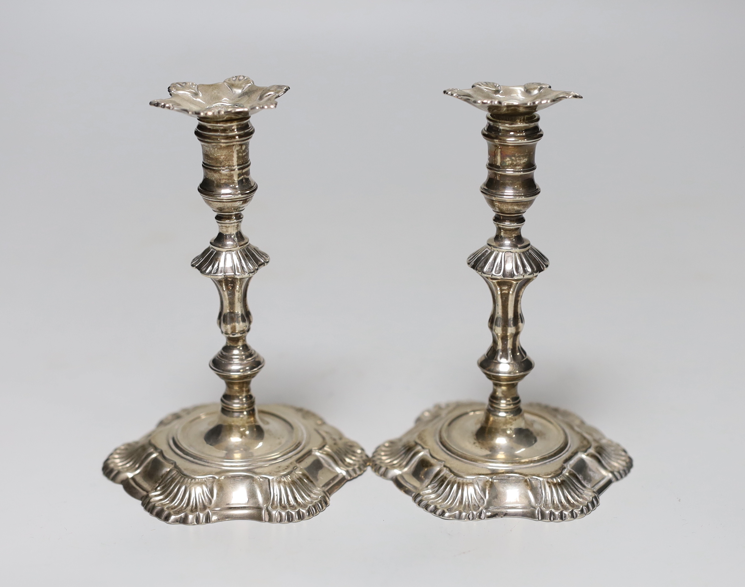 A pair of George II cast silver taper sticks, with unmarked nozzles, by John Cafe, London 1749/1750, 12.6cm, 11.7oz.                                                                                                        