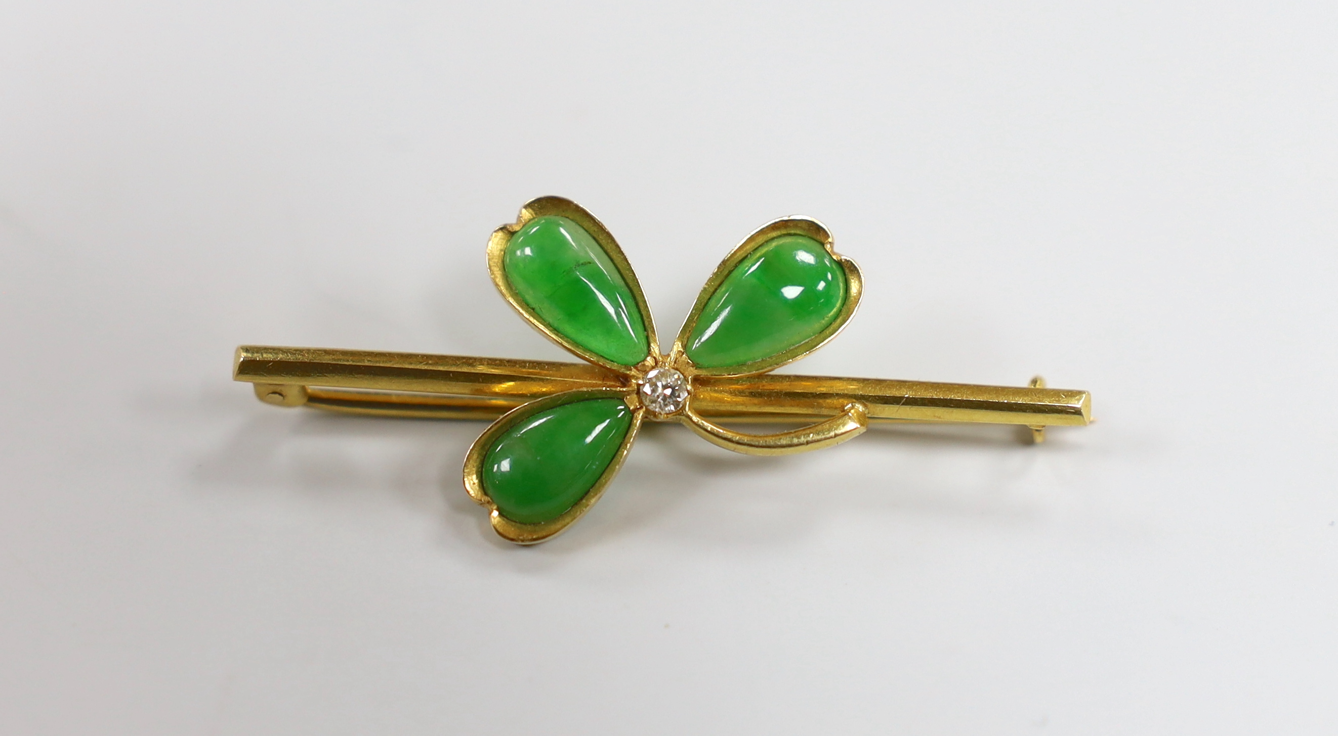 A Chinese yellow metal jade and diamond set petal bar brooch, 47mm, gross weight 4.9 grams, in fitted box.                                                                                                                  