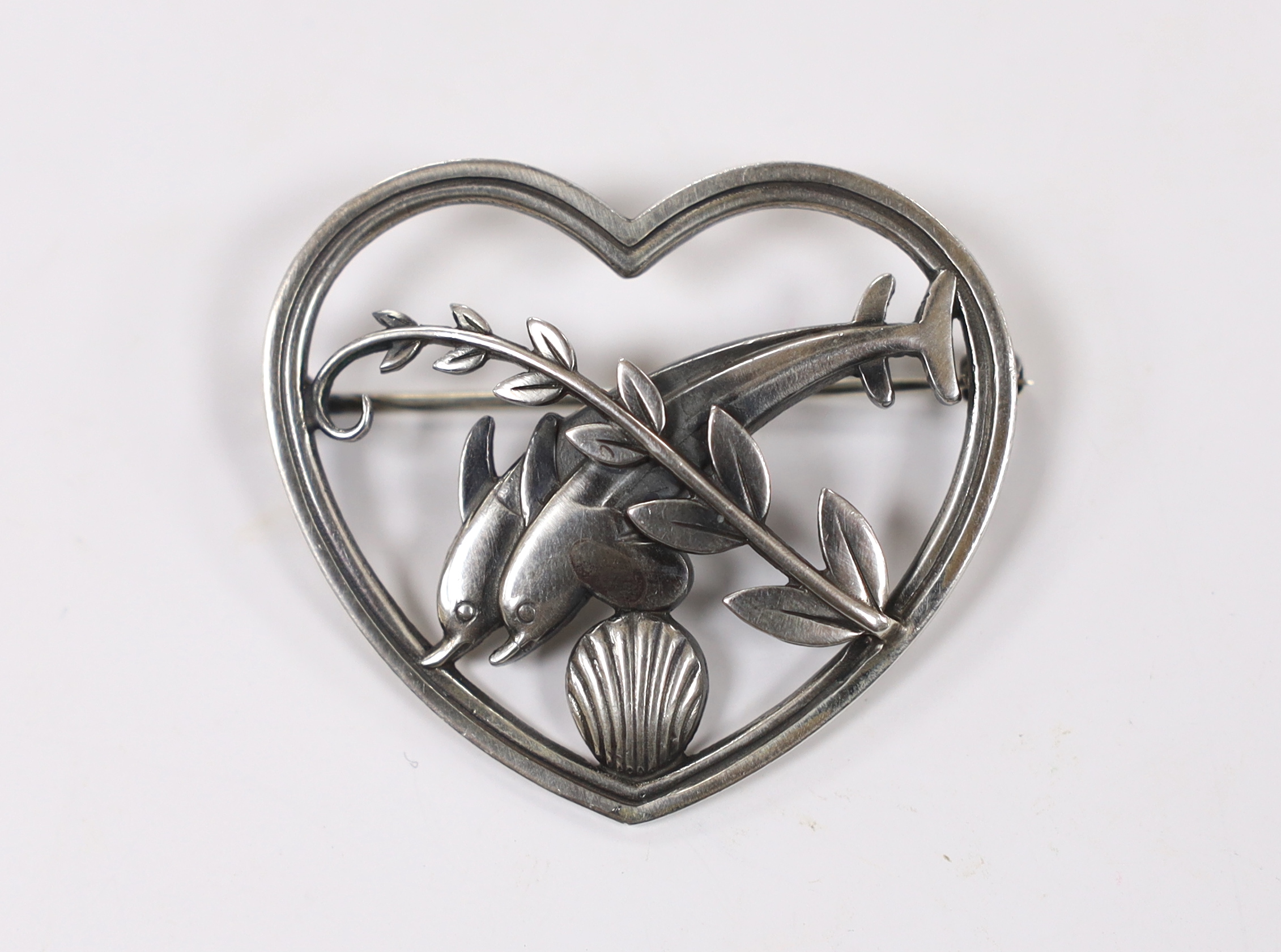 A George Jensen sterling 'twin dolphin, shell and frond' heart shaped brooch, design no. 312, width 41mm.                                                                                                                   
