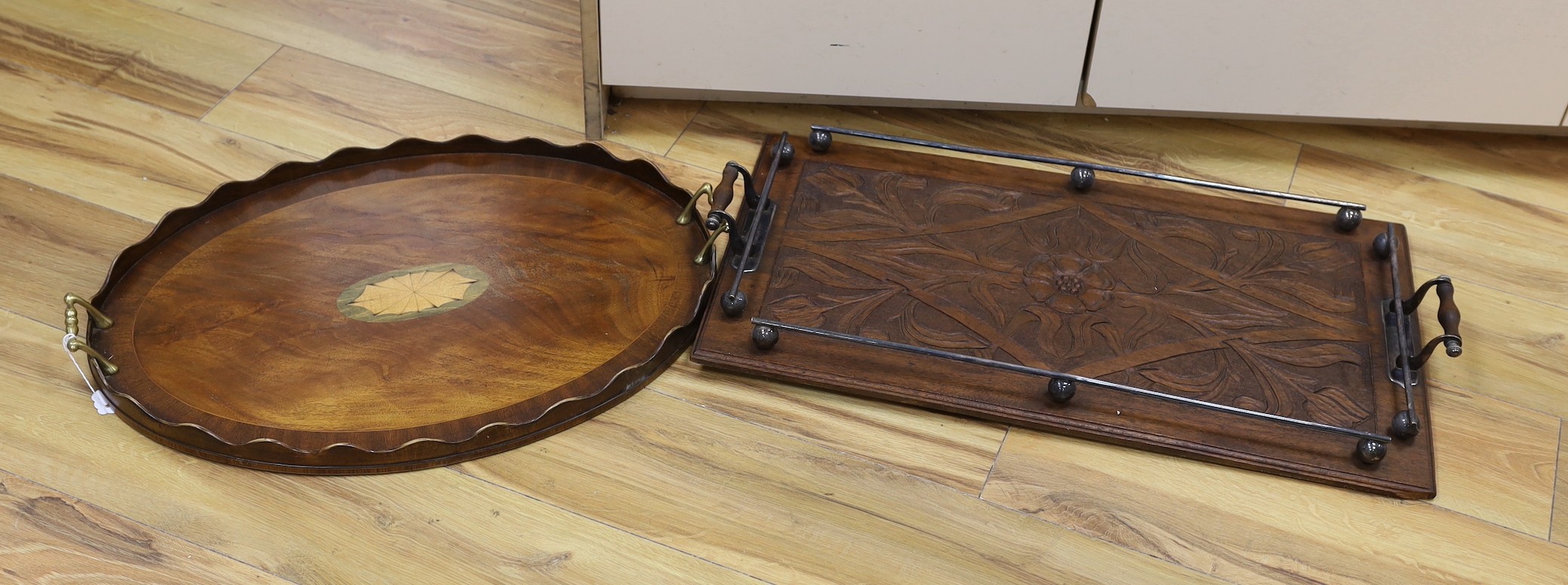 An oval, shell inlaid, pie crust tray and a carved oak rectangular tray, with chrome gallery and handles, oak tray 67 cms wide.                                                                                             