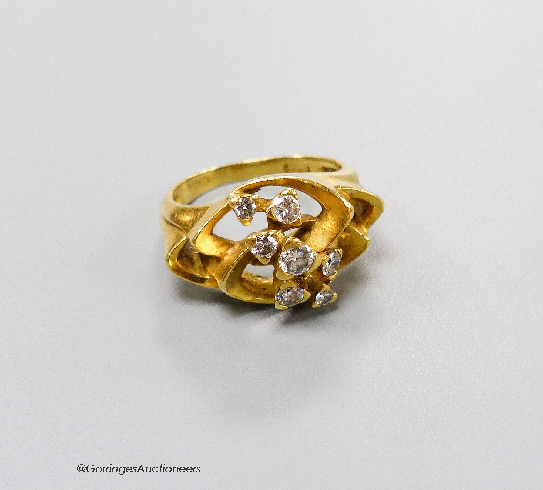 A 1970's? 18ct gold and seven stone diamond set modernist ring, size M, gross 8.7 grams.                                                                                                                                    