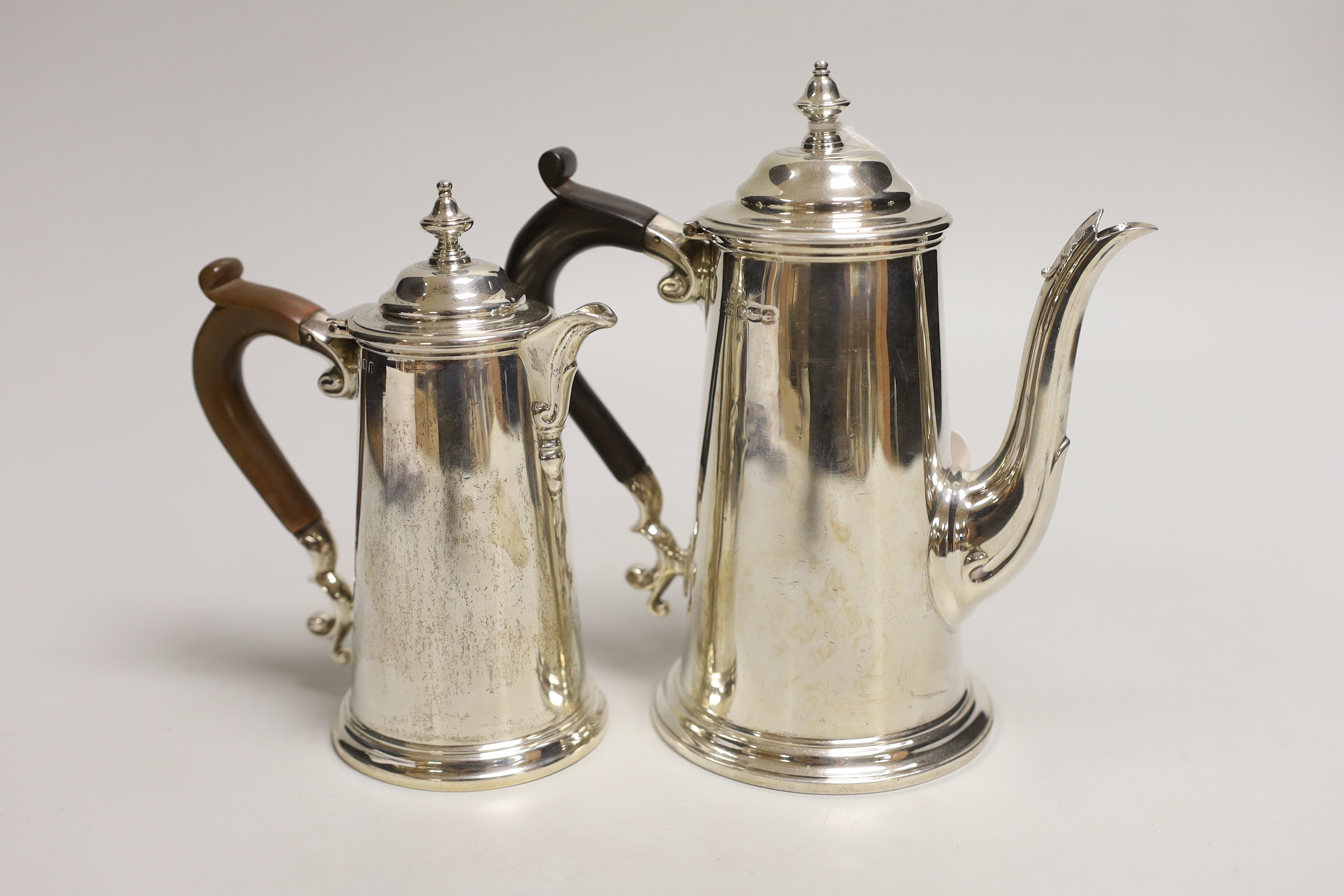 Two George V silver cafe au lait pots, the smaller by Chares & Richard Comyns, London, 1926, gross weight, 18.2oz.                                                                                                          