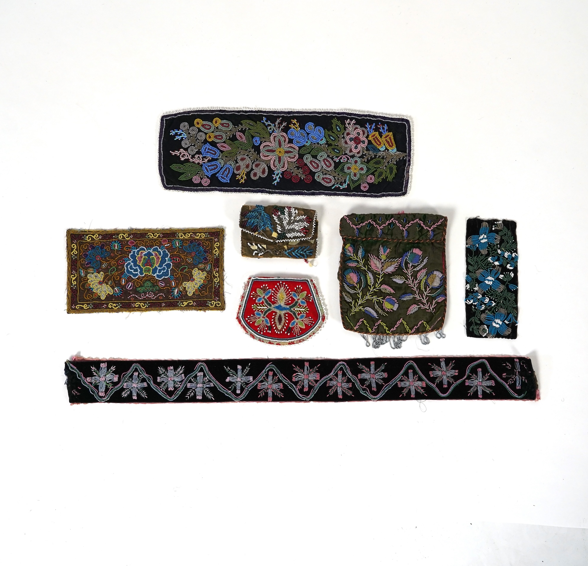 A 19th century black felt multi coloured beadwork panel, possibly North American Indian and a similar purse, a Regency fine bead worked bible bag, a similar worked belt and small panel, a red bead work purse and a small 