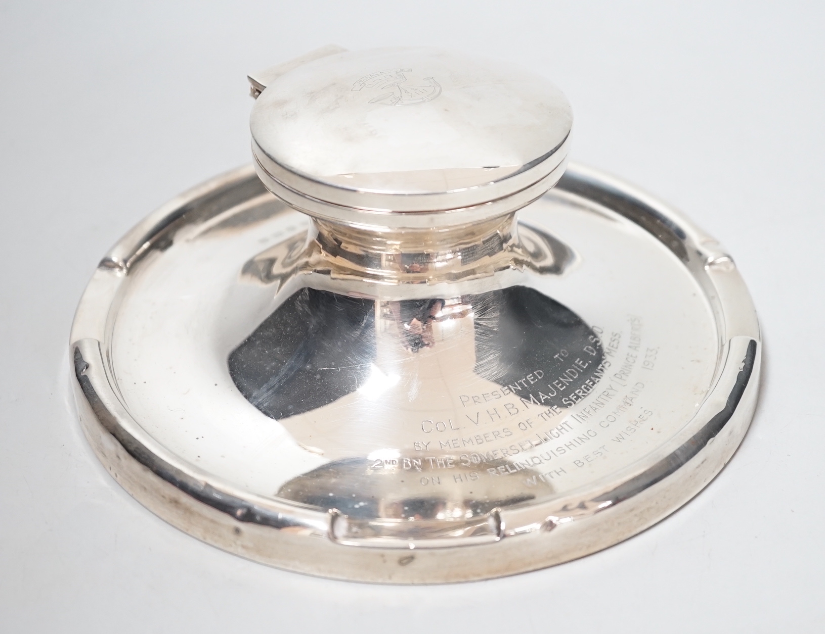 A George V silver mounted capstan inkwell, with Light Infantry related inscription, A & J Zimmerman, Birmingham, 1931, diameter 17.7cm.                                                                                     