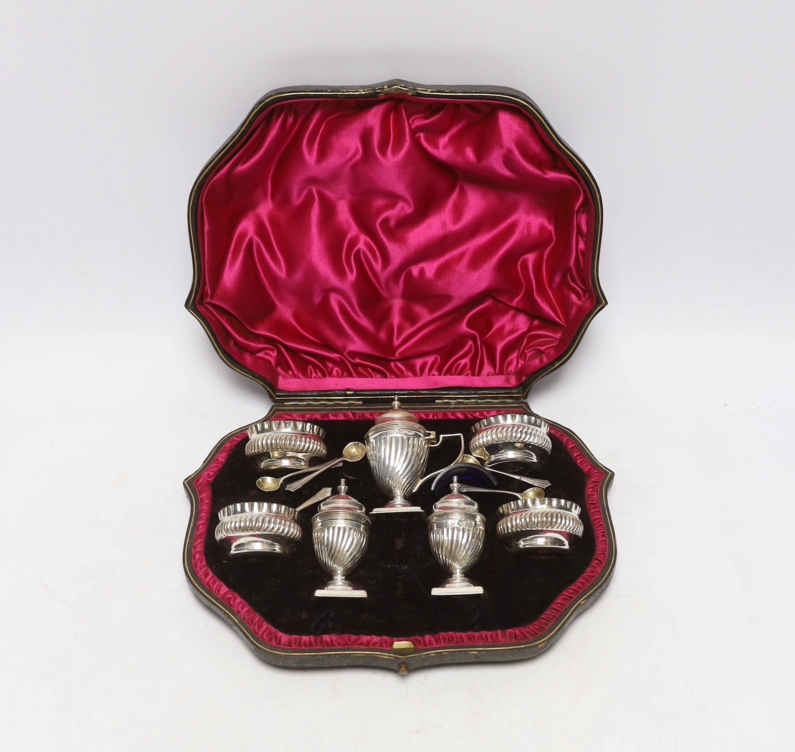 A cased late Victorian seven piece silver condiment set, Josiah Williams & Co Ltd, London, 1898, with five matching spoons.                                                                                                 