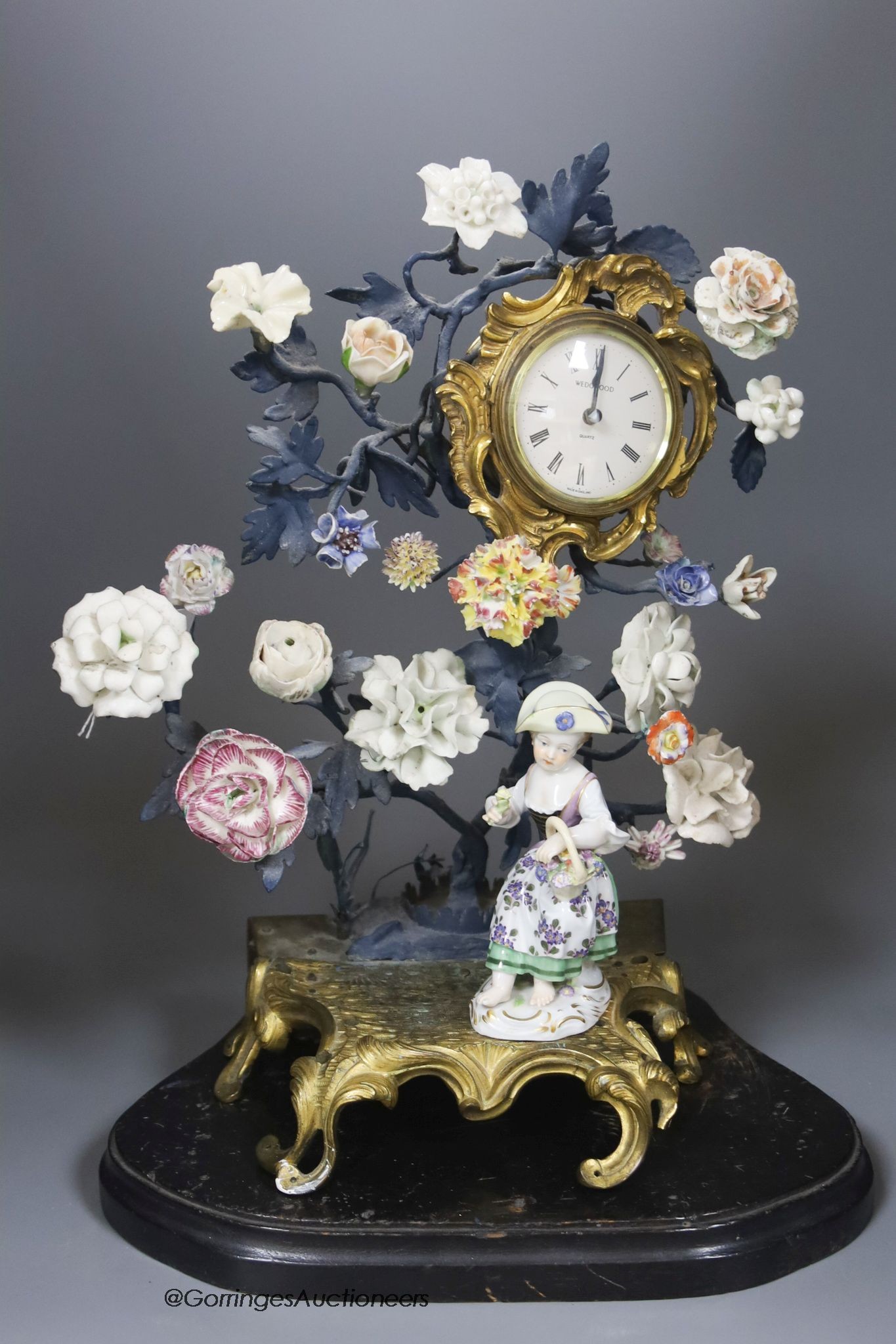 A 19th century and later Continental porcelain and ormolu floral timepiece with Meissen figure                                                                                                                              