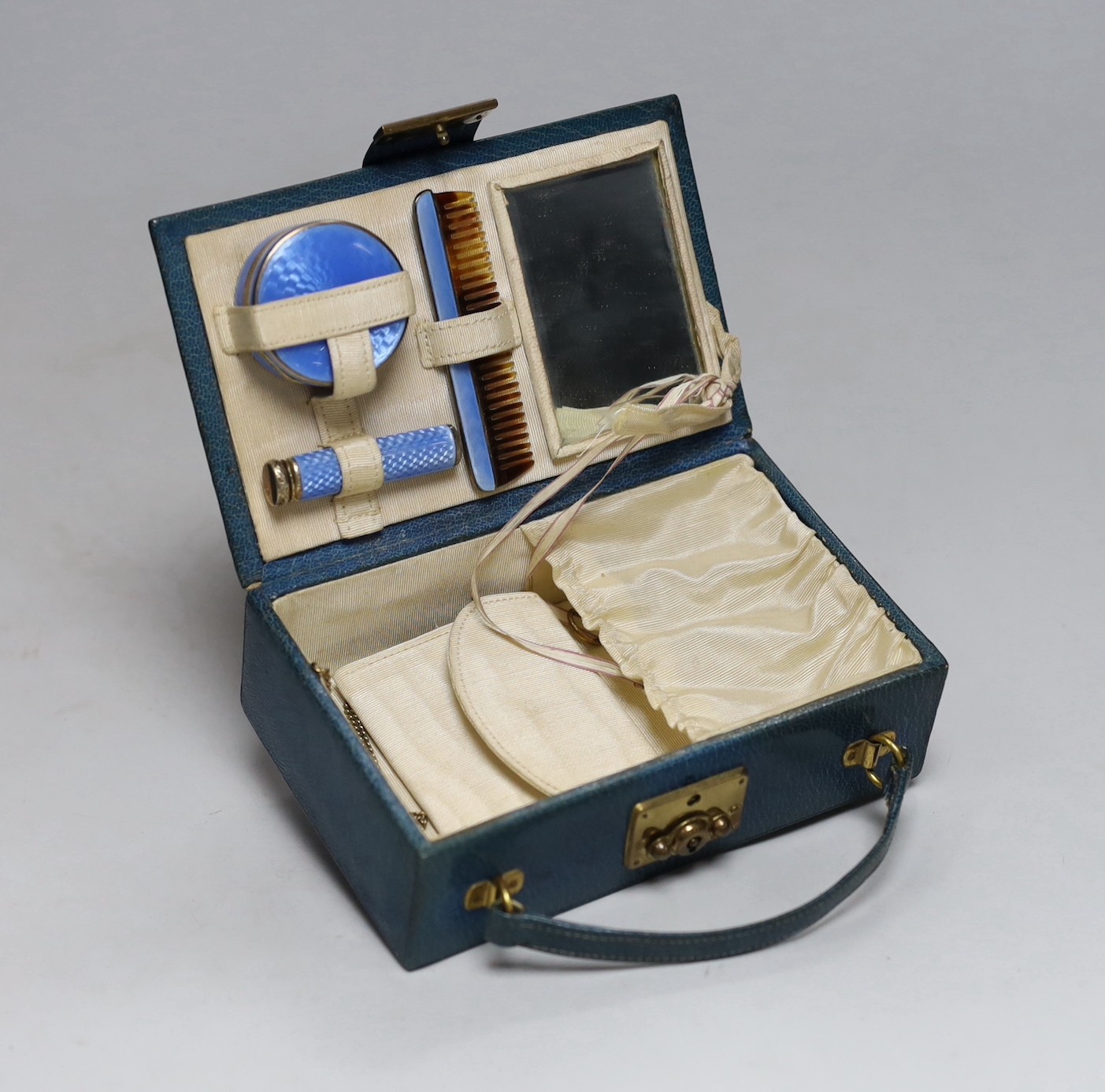 A lady's 1920's small leather vanity case, containing an enamelled comb, pill box and lipstick holder, the latter two with silver hallmarks, one for Cohen & Charles, London, 1926, the other with import marks only, case 1