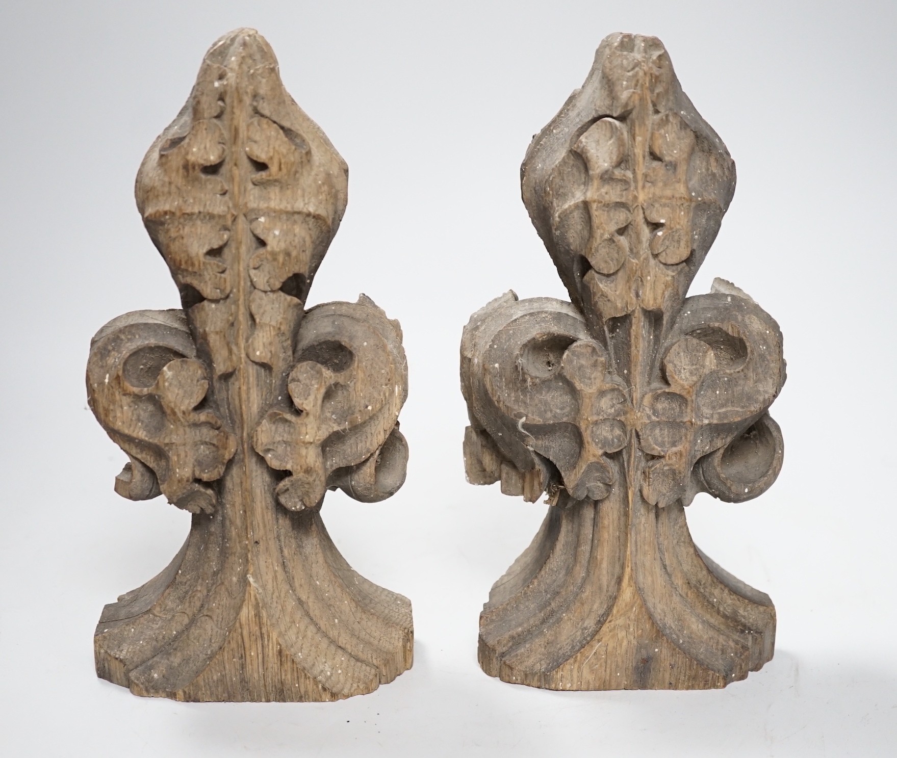 A pair of 16th century oak fleur de lys pew finials, 24cms high                                                                                                                                                             