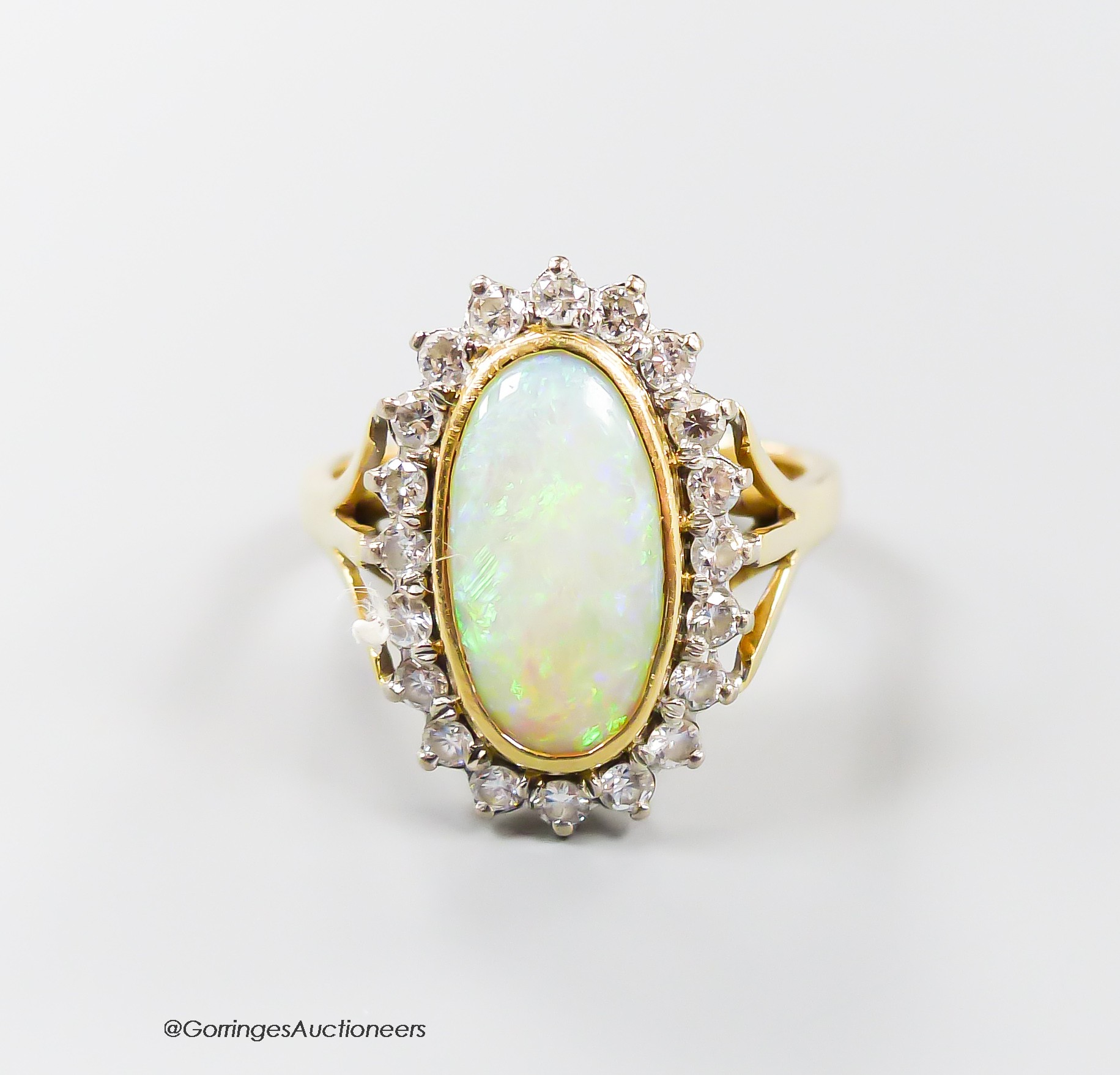 An 18ct, white opal and diamond set oval cluster ring, size N, gross 6.2 grams.                                                                                                                                             