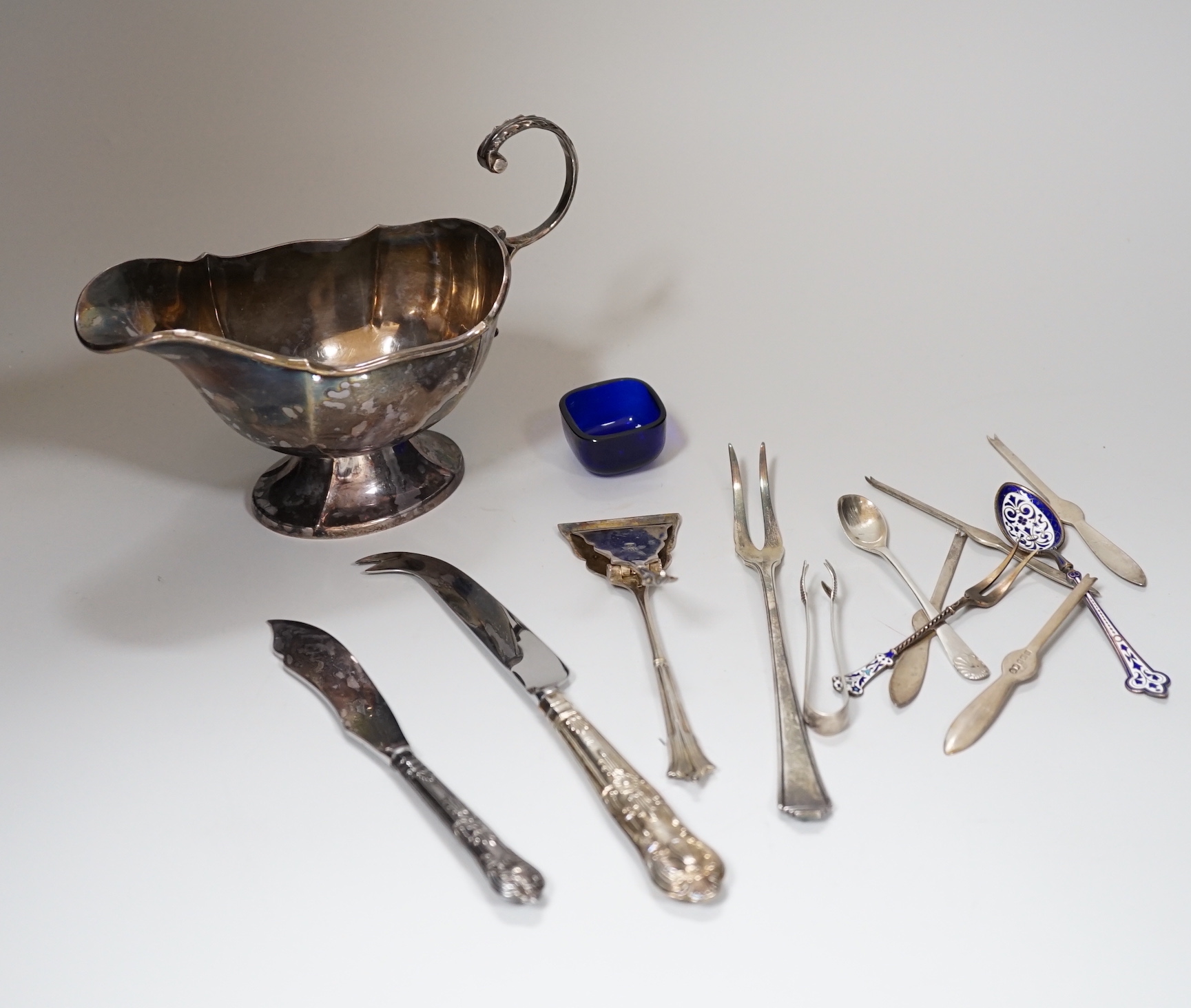 A group of assorted silver including a George V silver sauceboat, with flying scroll handle, Sheffield 1934, 188 grams, four silver lobster picks, a pair of sugar tongs, a sprung server and sundry other items including 8