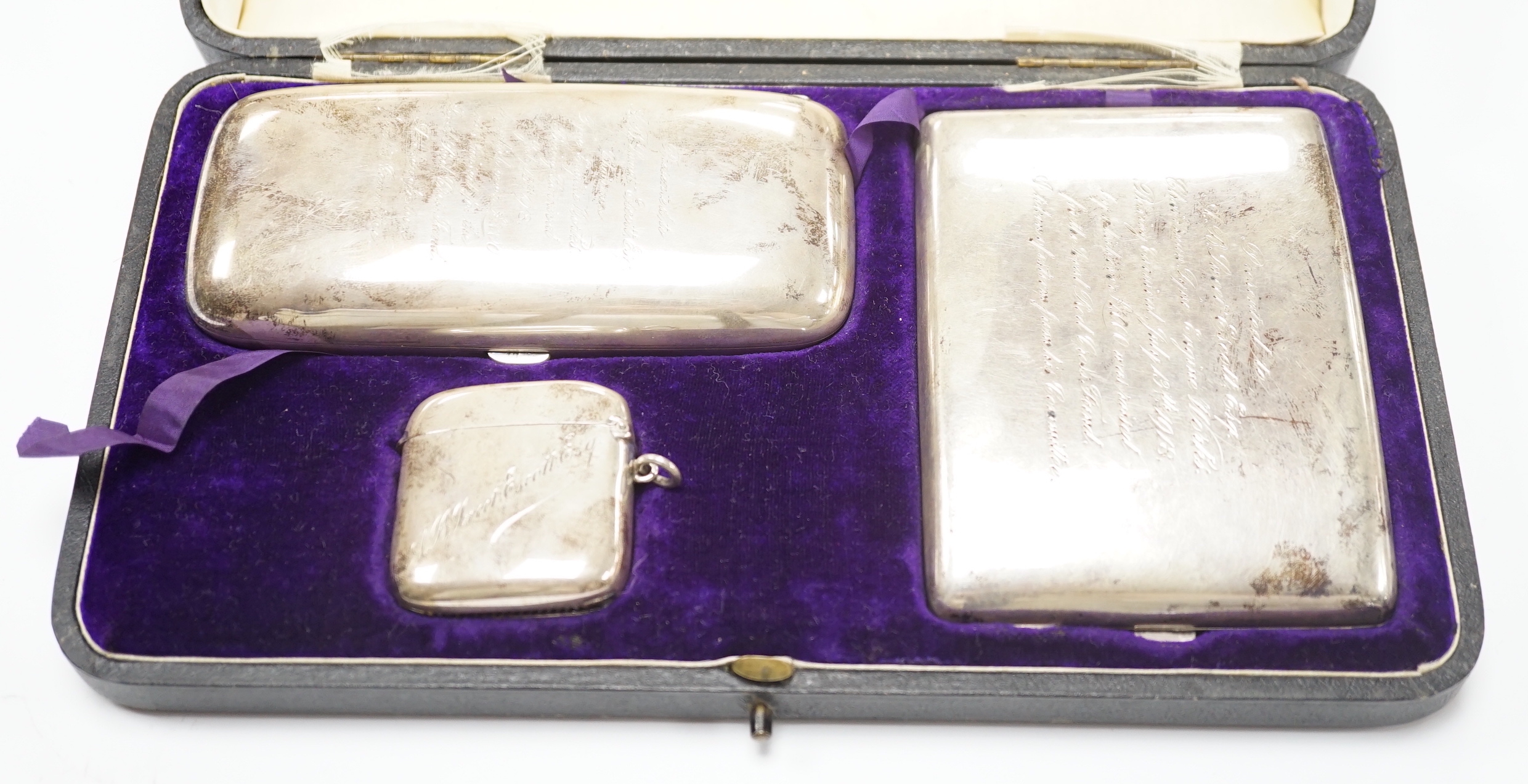 A George V cased silver three piece smoker's set, comprising a cigar, cigarette and vesta case, Walker & Hall, Birmingham, 1917/8/9, gross weight 10.8oz.                                                                   