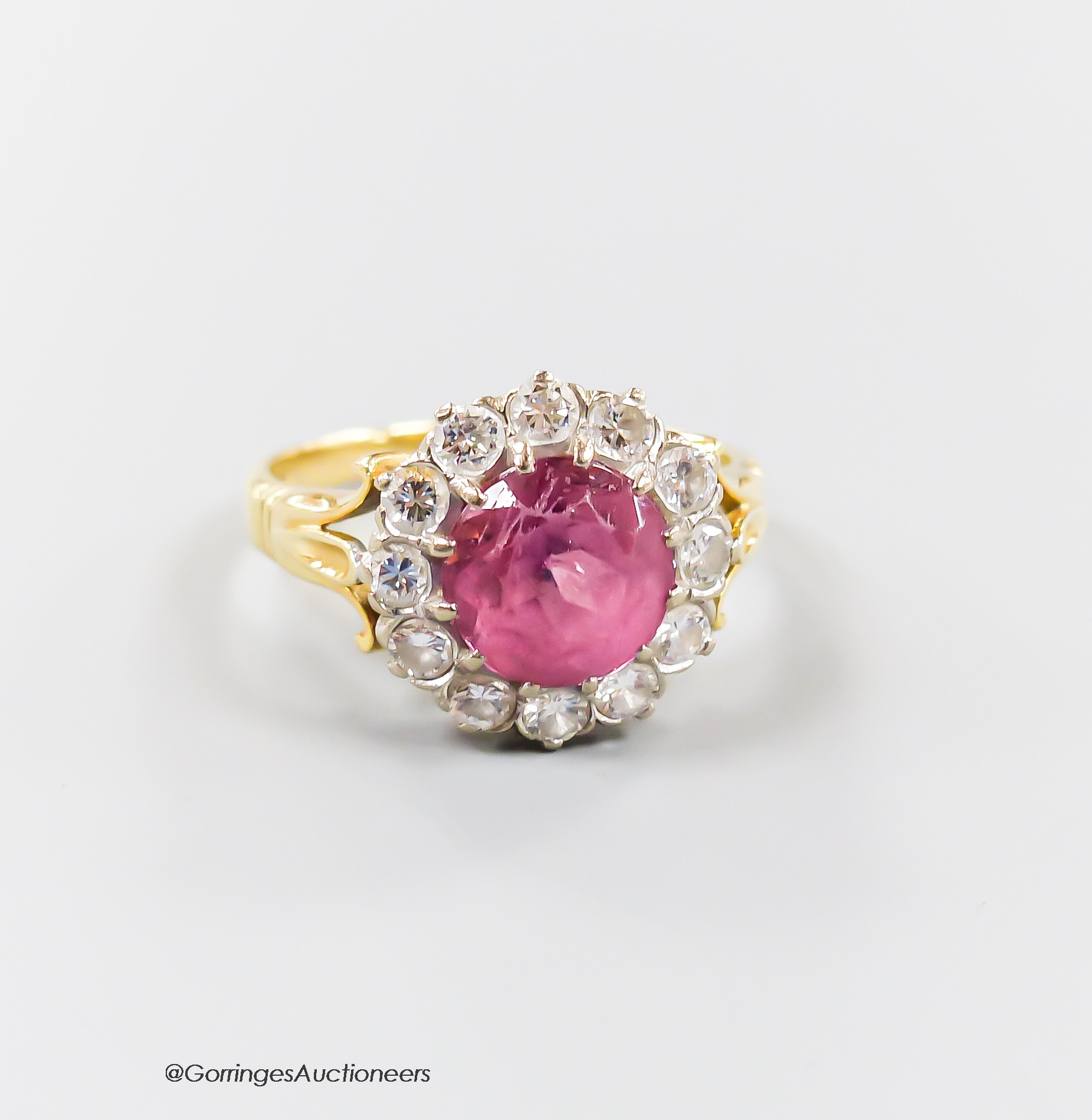 A modern yellow metal, pink tourmaline and diamond set circular cluster ring, size O, gross 5.1 grams.                                                                                                                      